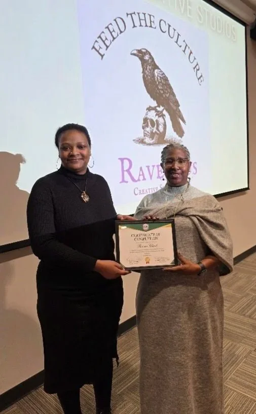 Two women smiling while one gives the other a certificate.