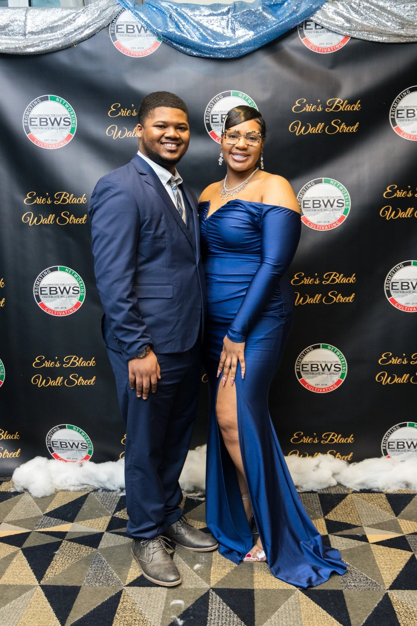 Young couple, dressed in formal wear, smiling.