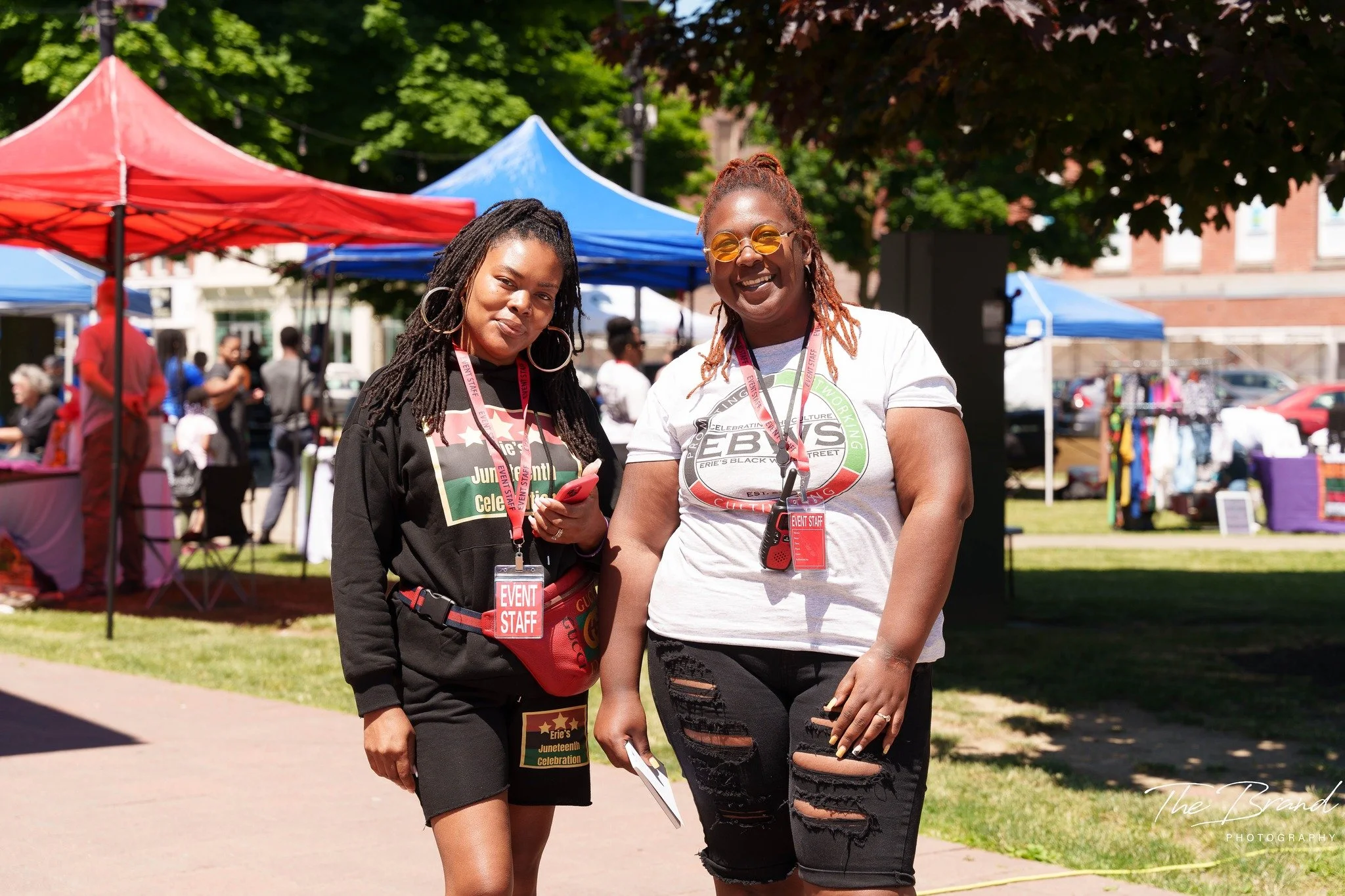 Two women smiling at an outdoor festival.