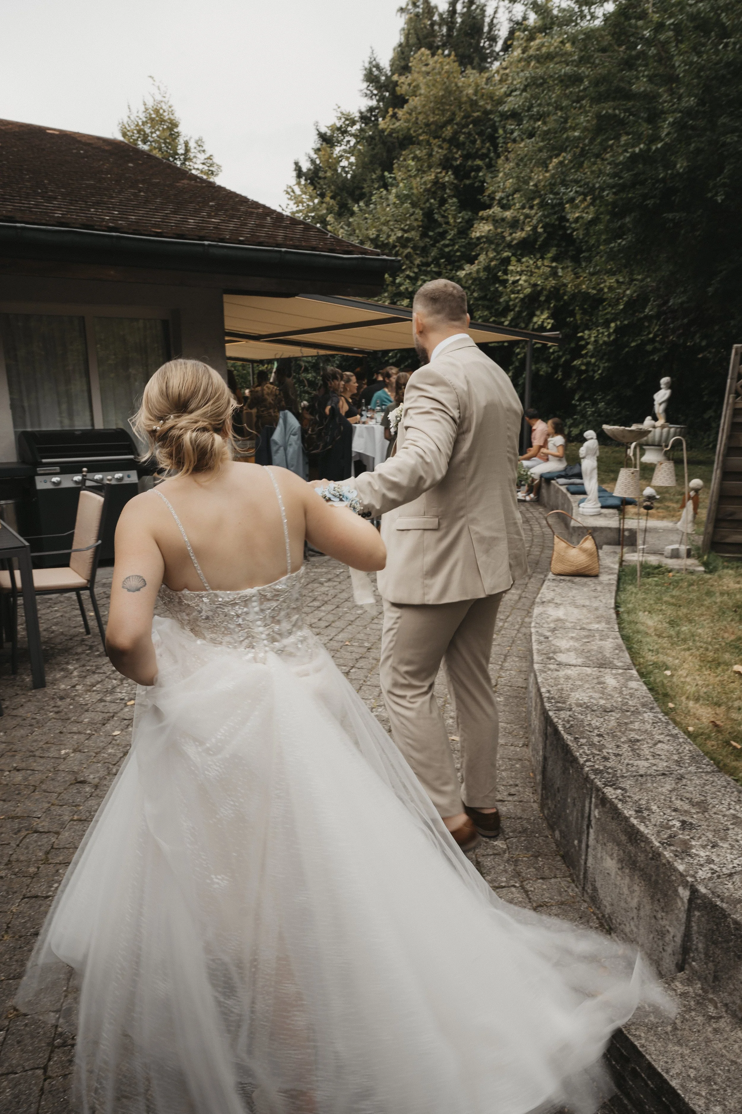 Braut und Bräutigam tanzen bei einer Hochzeitsfeier im Freien, umgeben von Gästen und Dekorationen.