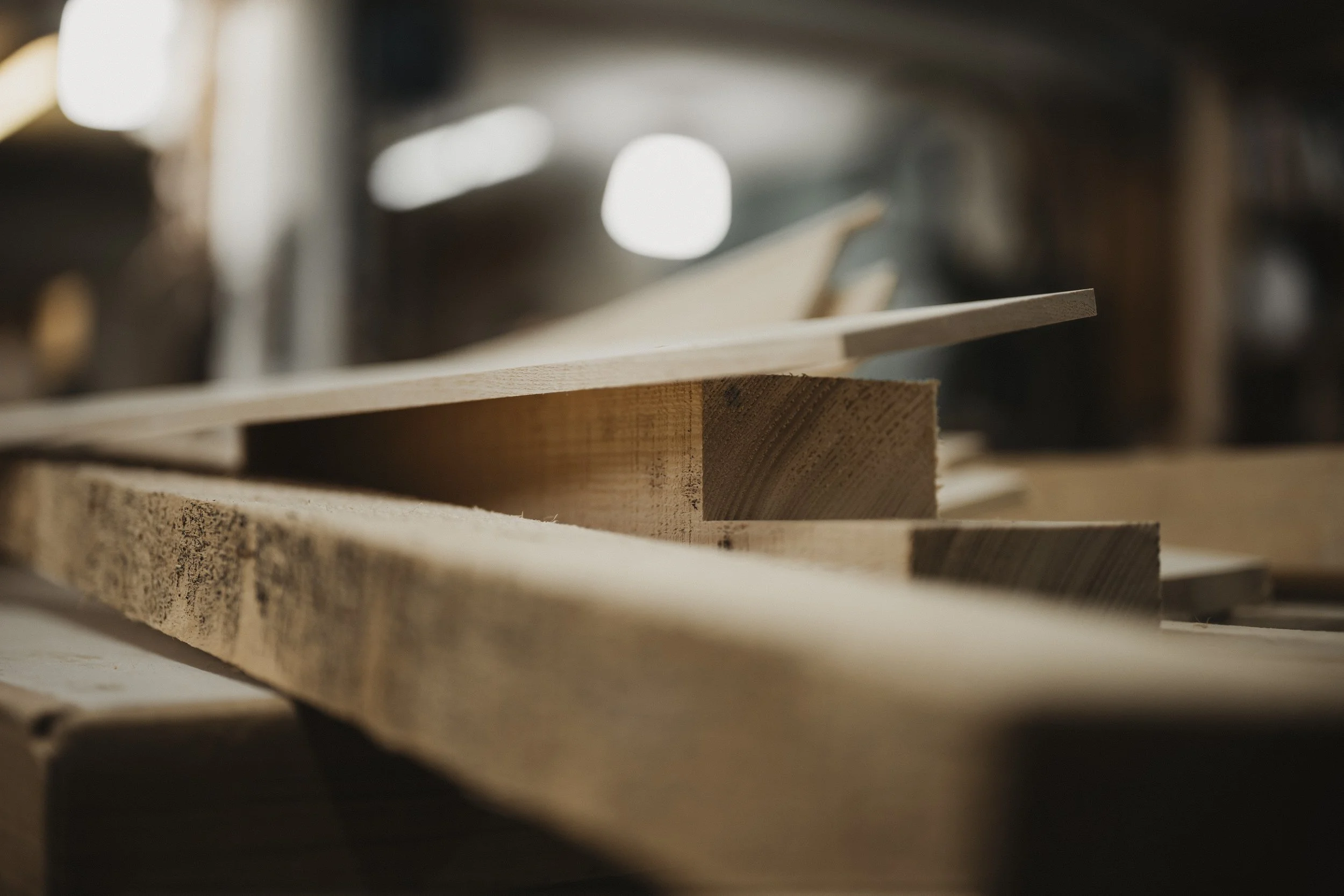 Nahaufnahme von Holzbohlen und Spanplatten in einem Holzwerkstatt.