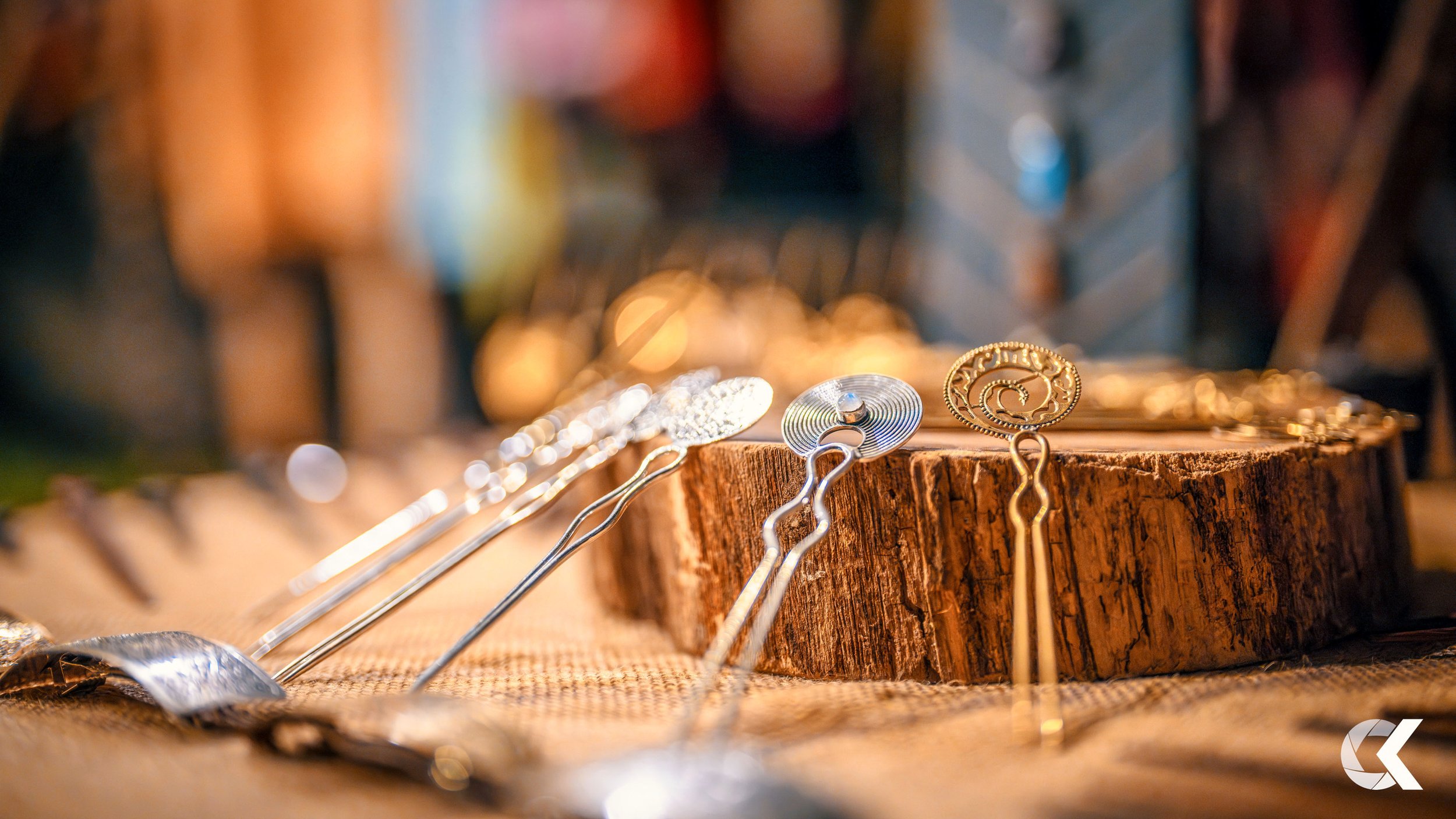 Assorted metal jewelry pieces displayed on a wooden surface with a blurred background.