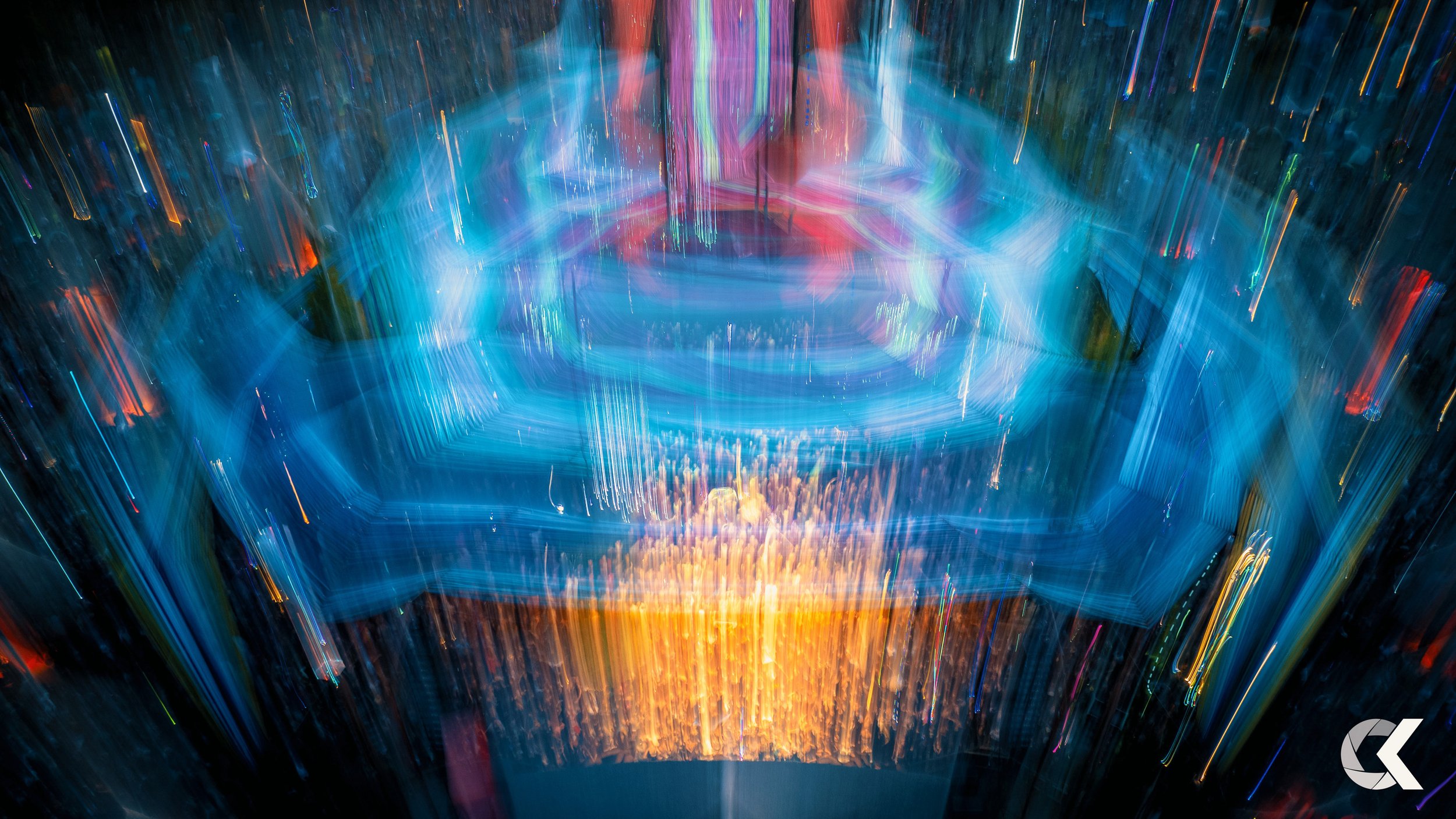 Abstract long exposure photograph of colorful, neon lights creating streaks and patterns in a dark environment.