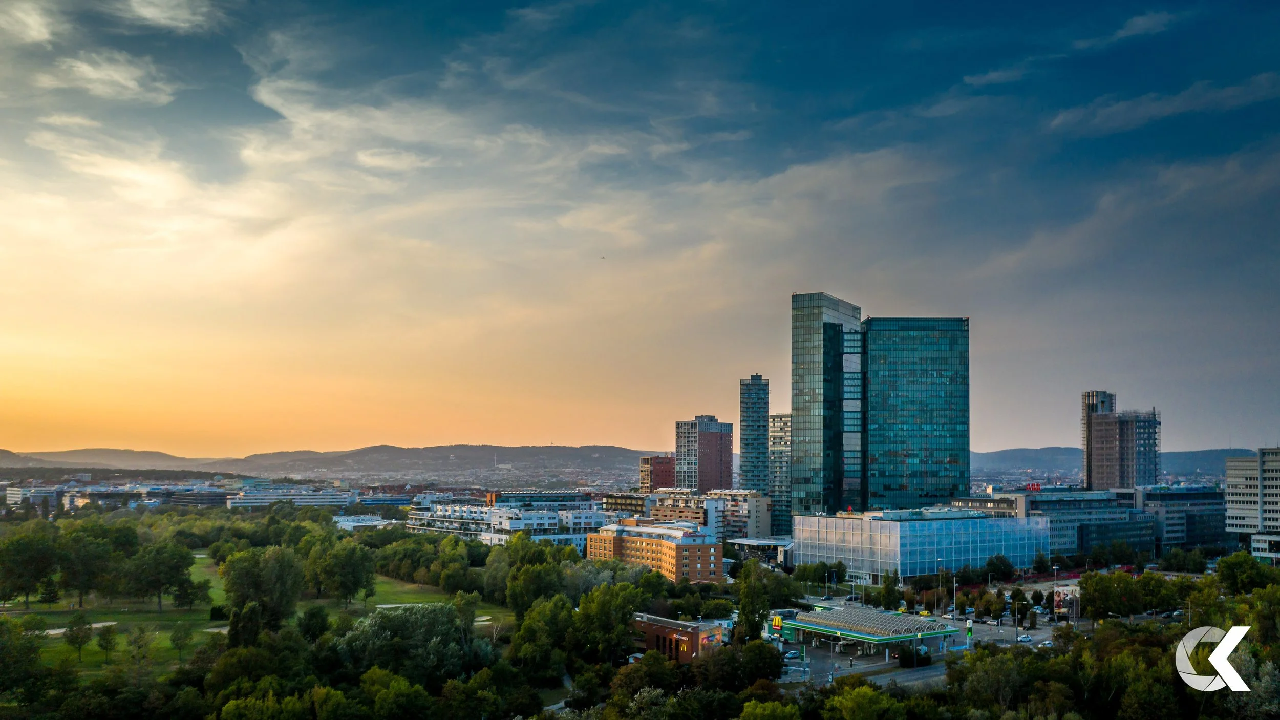 City skyline with modern skyscrapers and greenery park at sunset