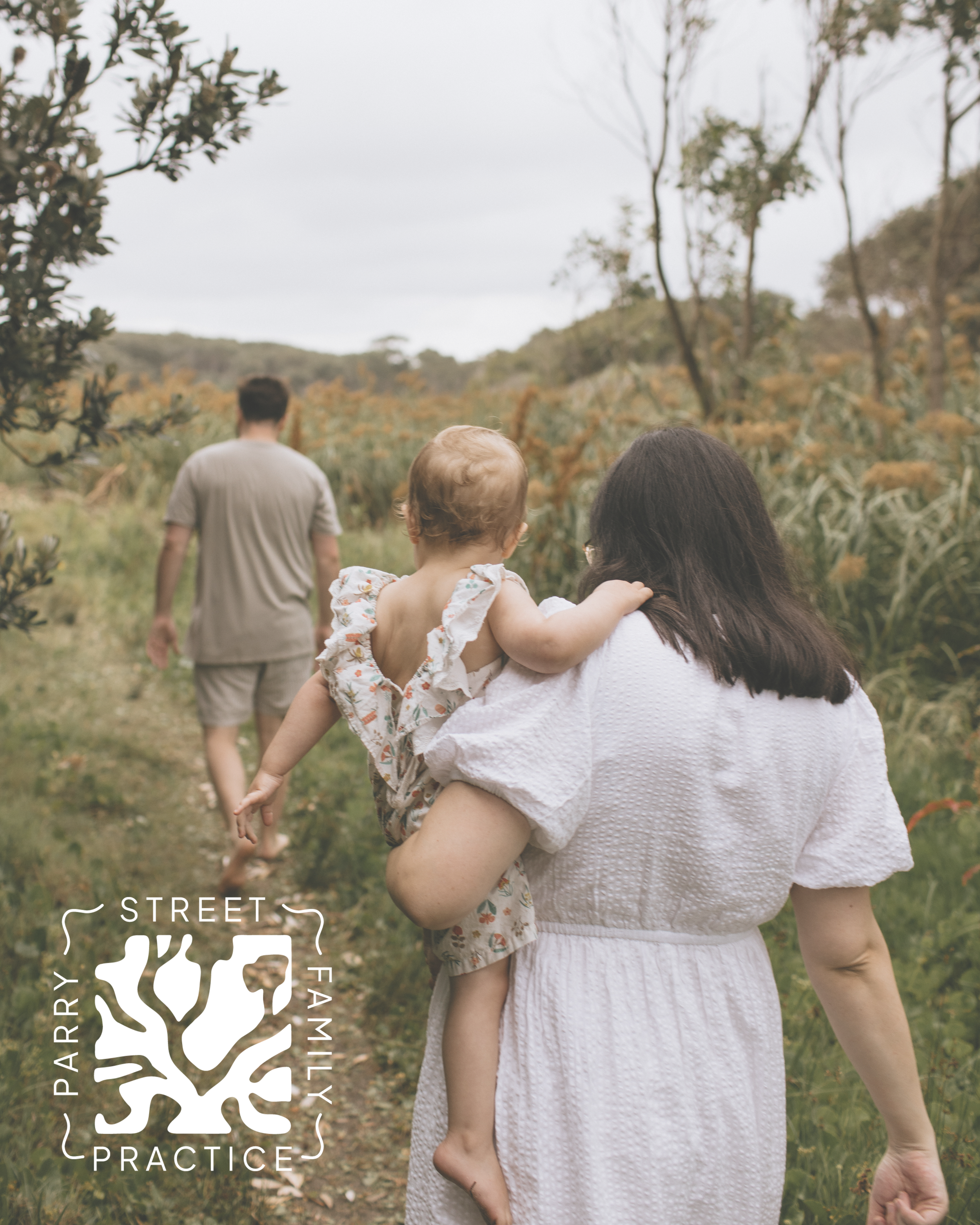 A woman carrying a young child on her back walking on a trail in a natural outdoor setting with trees and shrubs, and a man walking ahead in the distance. The image includes a logo for 'Parry Street Family Practice' in the bottom left corner.