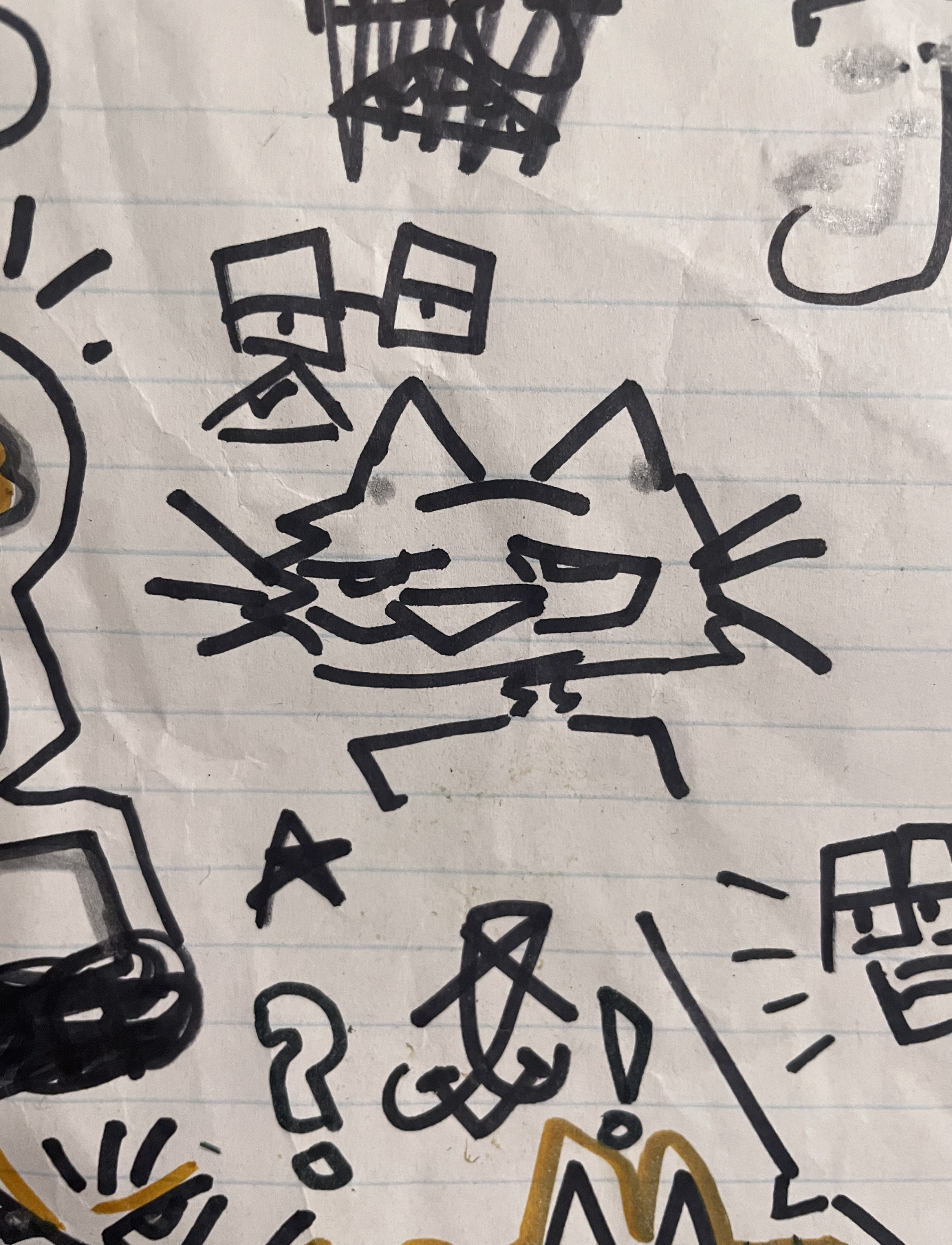 Hand-drawn doodles of a cat face, a piece of cheese, a question mark, and various abstract shapes on lined paper.