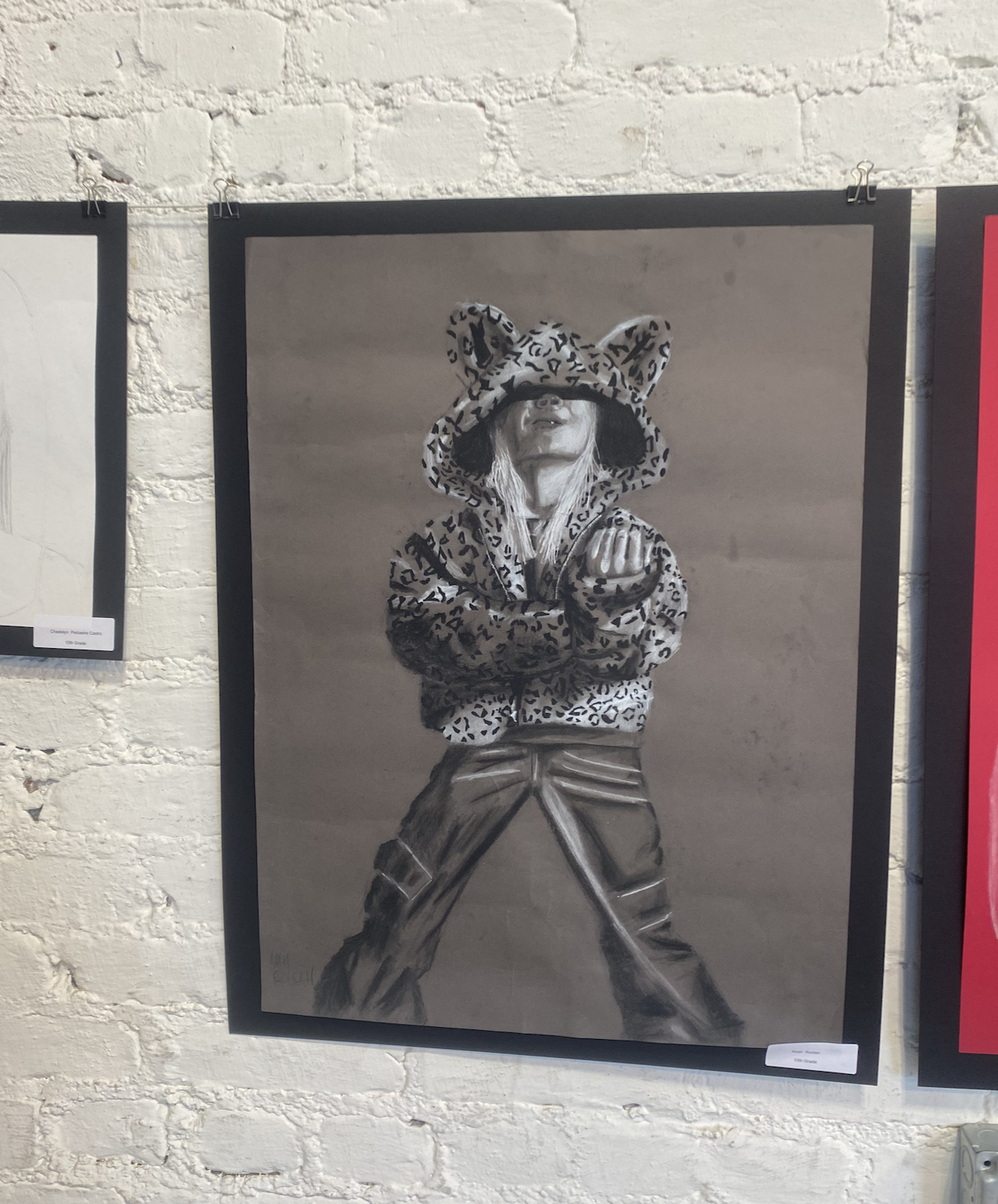 Black and white painting of a person standing with arms crossed, wearing a leopard print hoodie with bear ears and a matching jacket. The person's face is partially shaded under the hoodie.