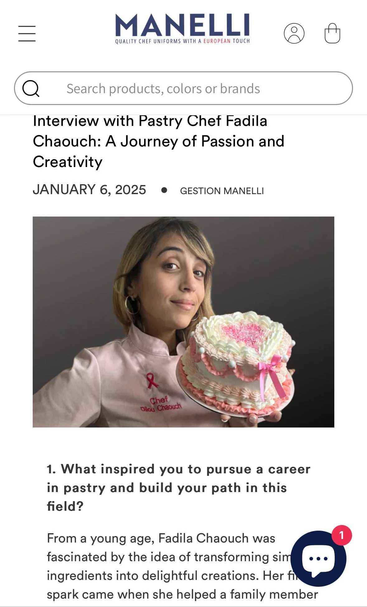 A woman wearing a chef uniform holding a heart-shaped cake decorated with pink and white frosting, a pink ribbon, and pink sprinkles.