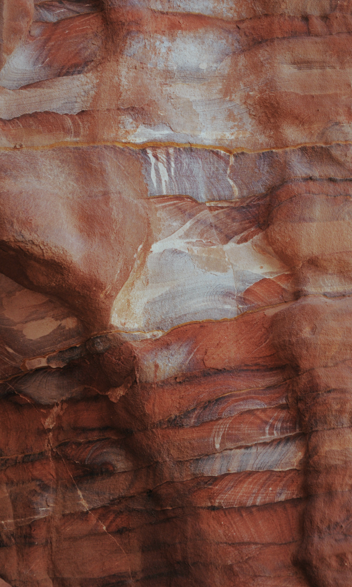 Close-up of layered red and orange sandstone rock formation with natural striations and textures.