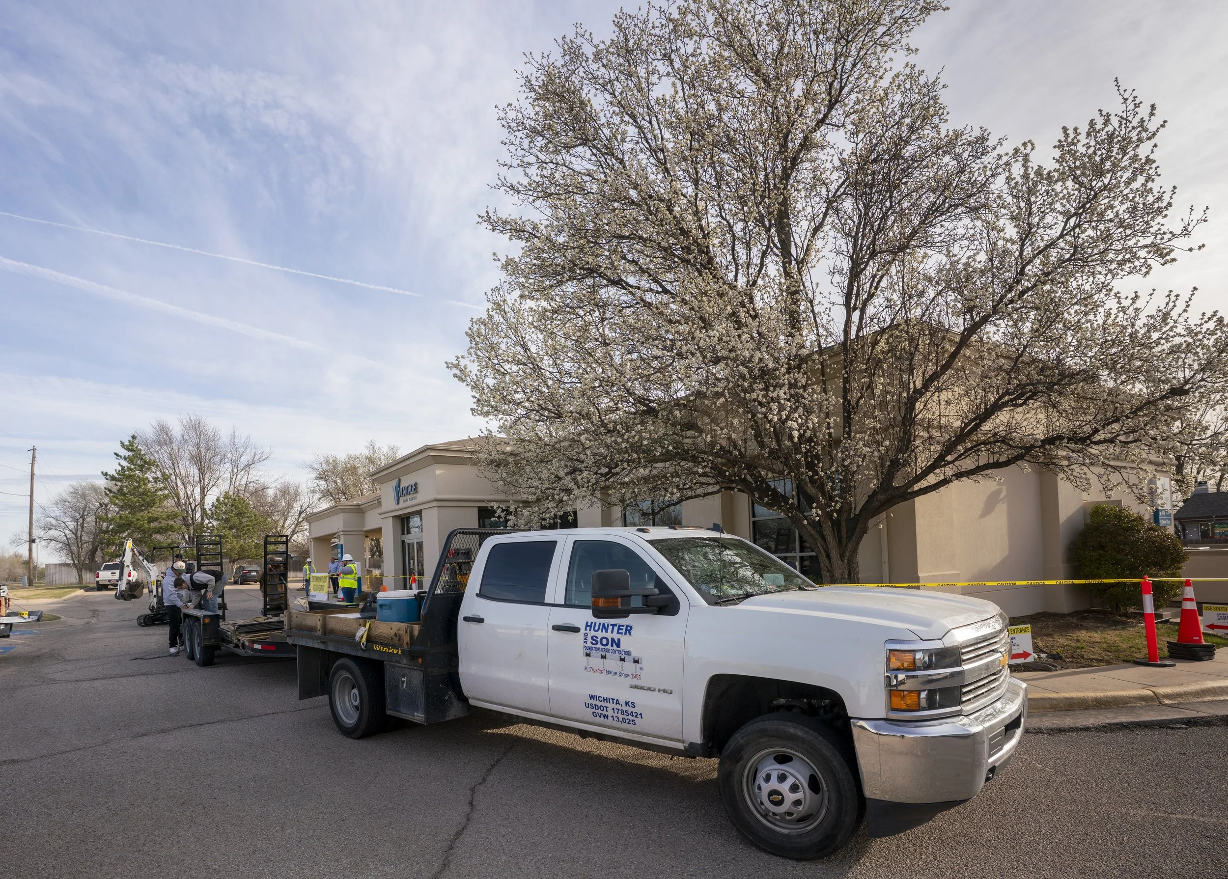 Our trucks unloading equipment to install helical piers on a bank foundation.