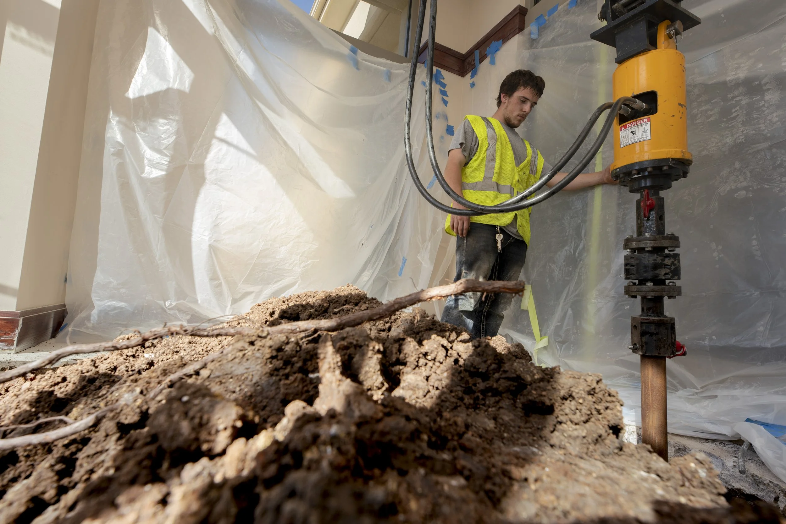 Ahelical pier being installed inside a bank lobby.
