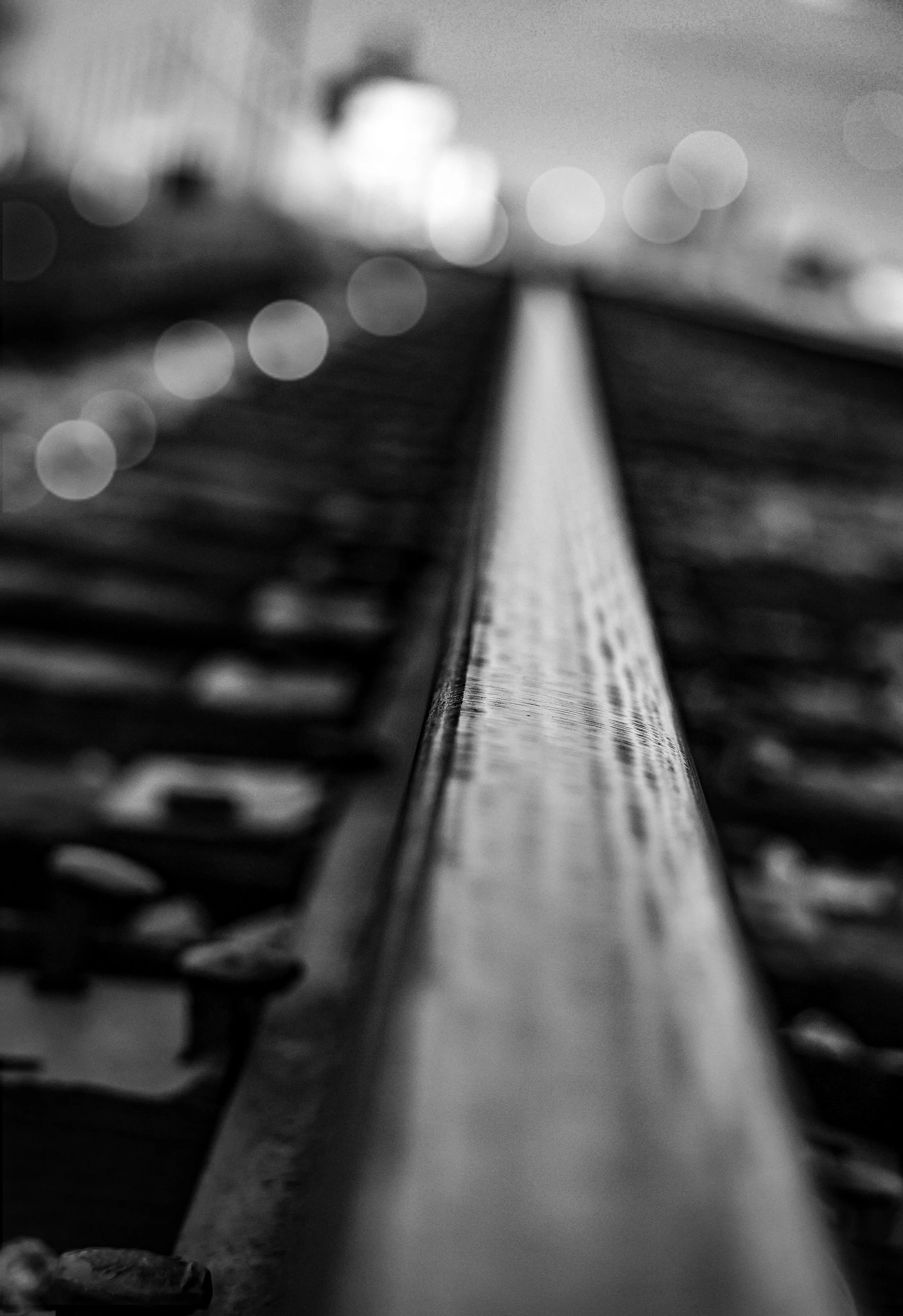 The rail disappears into blur and distance, carrying the feeling of somewhere not yet reached.