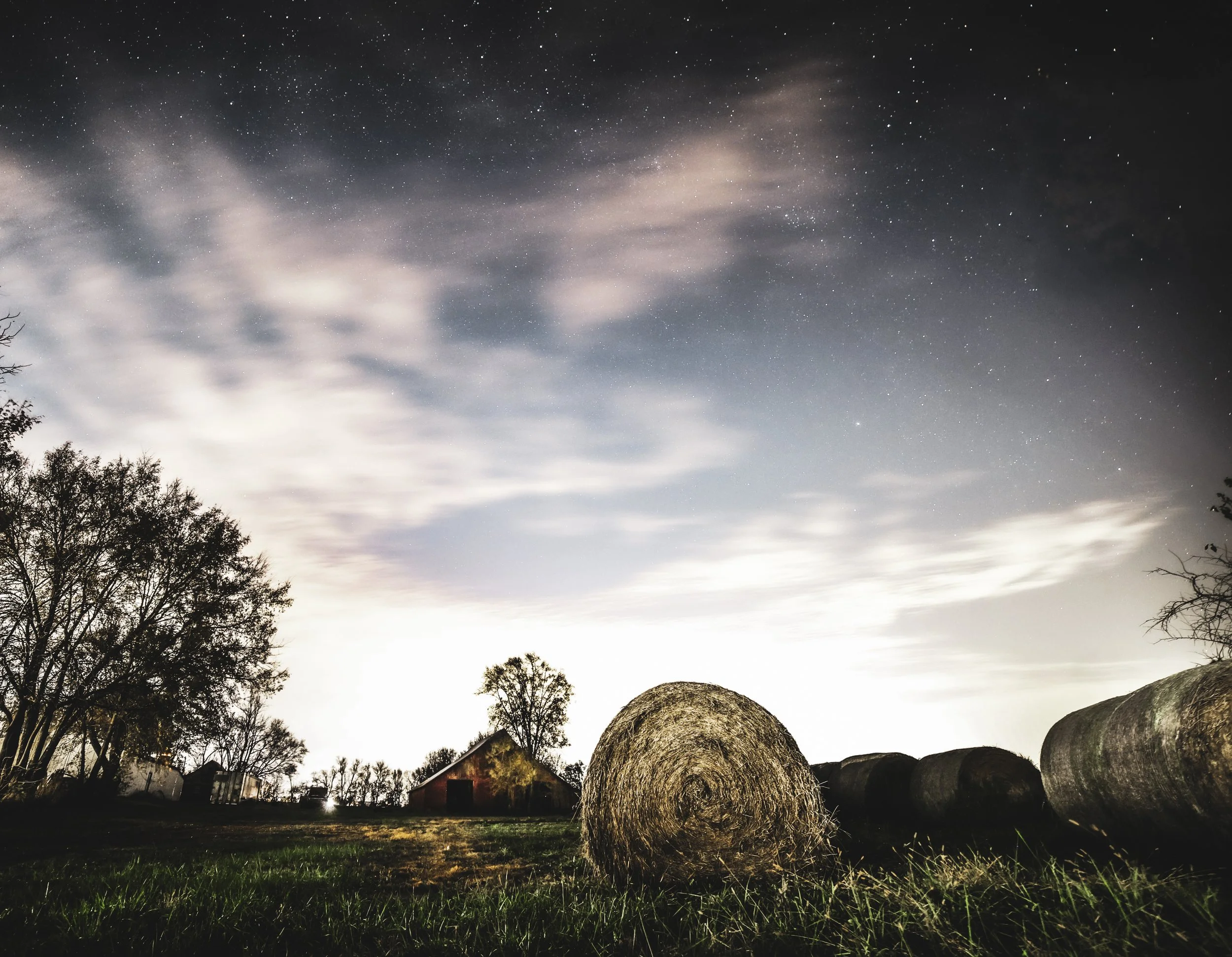 Beneath drifting clouds and a star-washed sky, the hay fields rested in the quiet of the night.