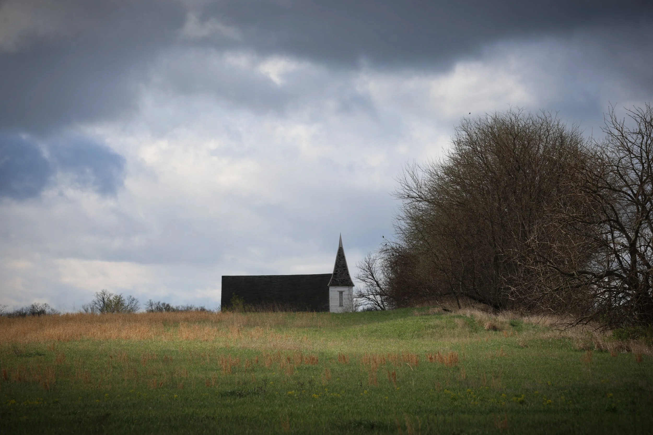 This little church sits on the rise like a quiet hymn carried by the prairie wind.