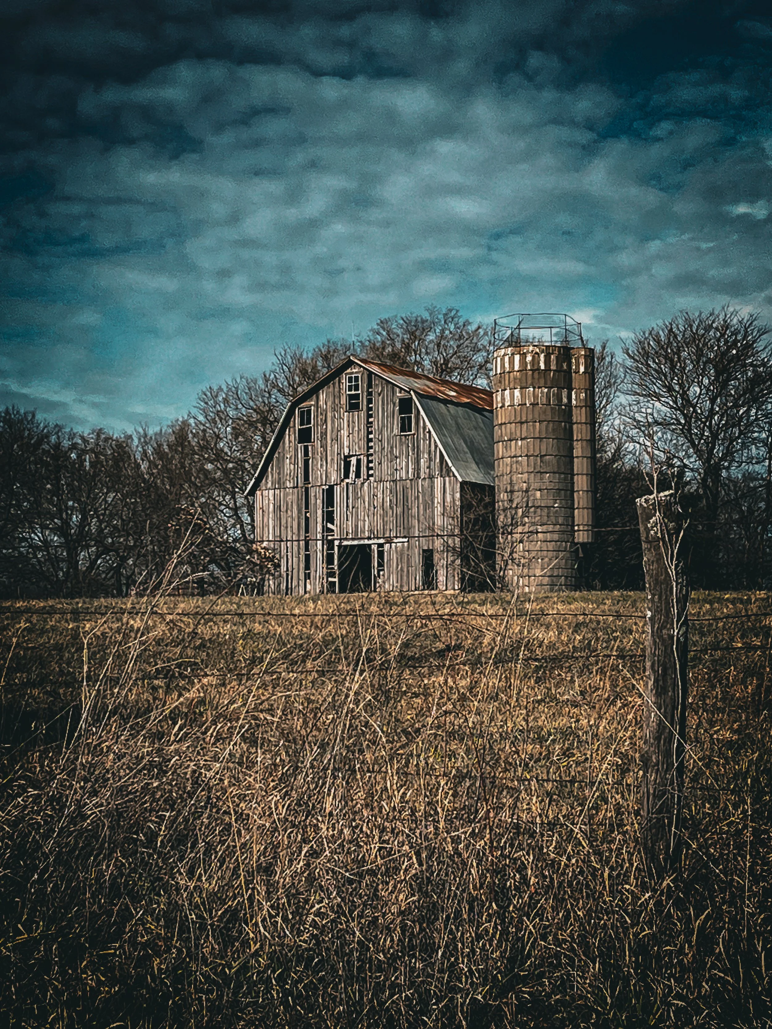 Beneath a sky full of gathering clouds, this old barn stands in quiet strength, holding the mood and stillness of the land.