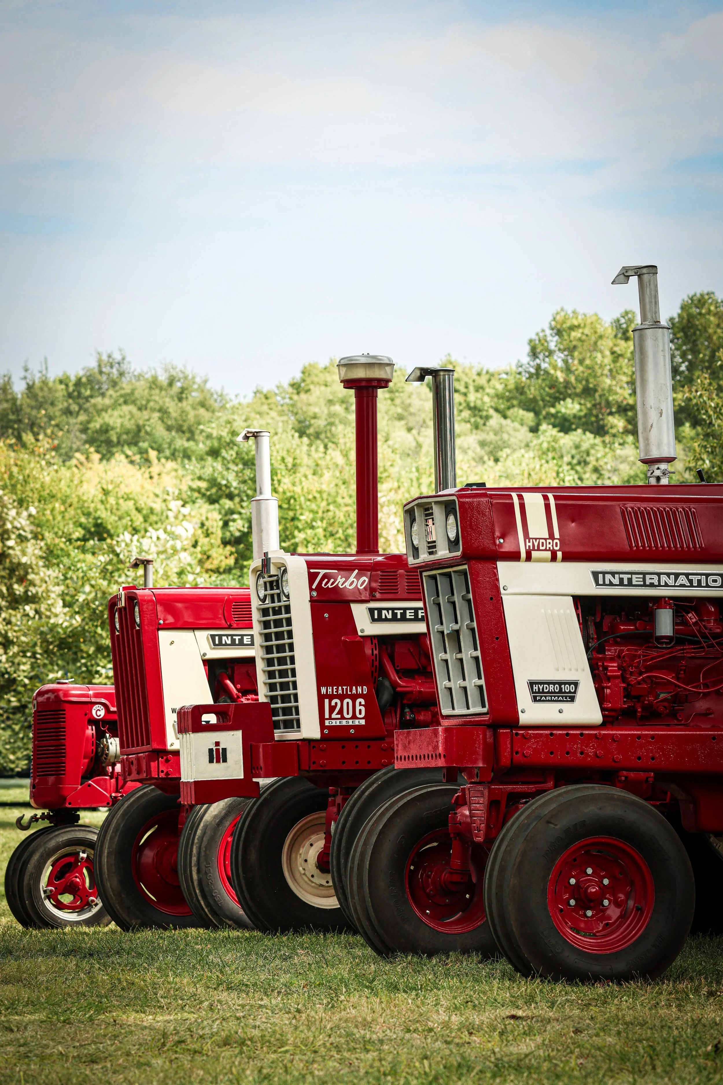 Standing together beneath the open sky, these International Harvester tractors carry the bold beauty and heritage of farm life.