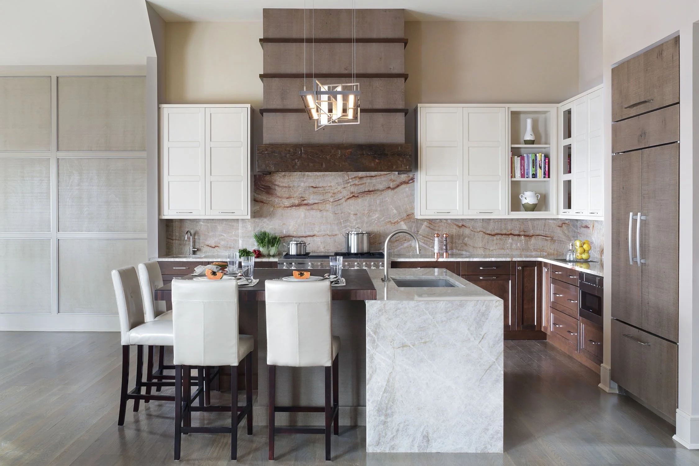 Asian elements of Pagoda styled hood and earthy textures of full quartzite backsplash and island waterfall panels make this kitchen unique. The Sub-Zero refrigerator and Wolf range make feasts easy.