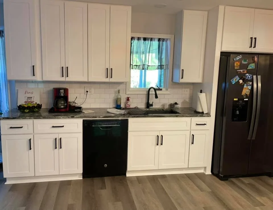 Kitchen remodel in Southaven, MS featuring custom white cabinets, quartz countertops, and luxury vinyl plank flooring by DeSoto Renovations.