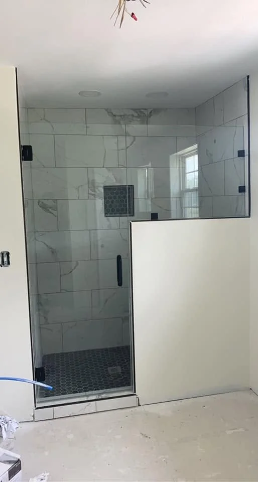 Custom bathroom remodel in Hernando, MS featuring a walk-in tile shower with frameless glass enclosure and marble-look tile by DeSoto Renovations.