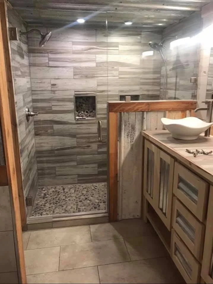Luxury bathroom remodel in Olive Branch, MS featuring a custom walk-in tile shower, frameless glass enclosure, pebble shower floor, custom vanity, and vessel sink by DeSoto Renovations.