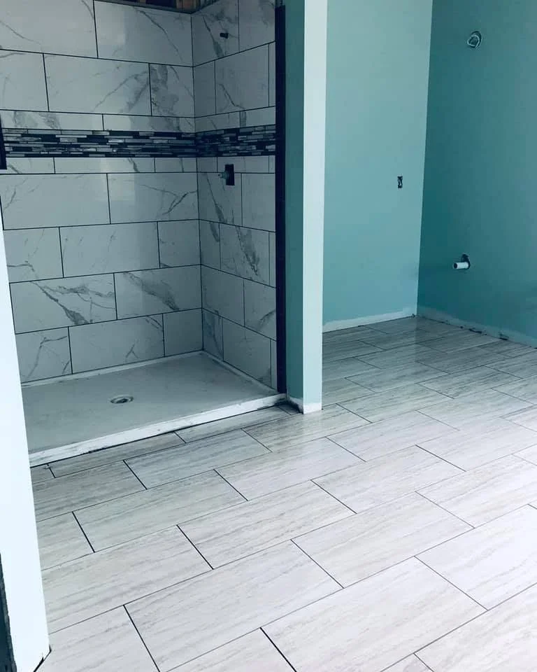 Professional bathroom remodeling completed in Olive Branch, MS with a custom shower, vanity, and tile flooring by DeSoto Renovations.