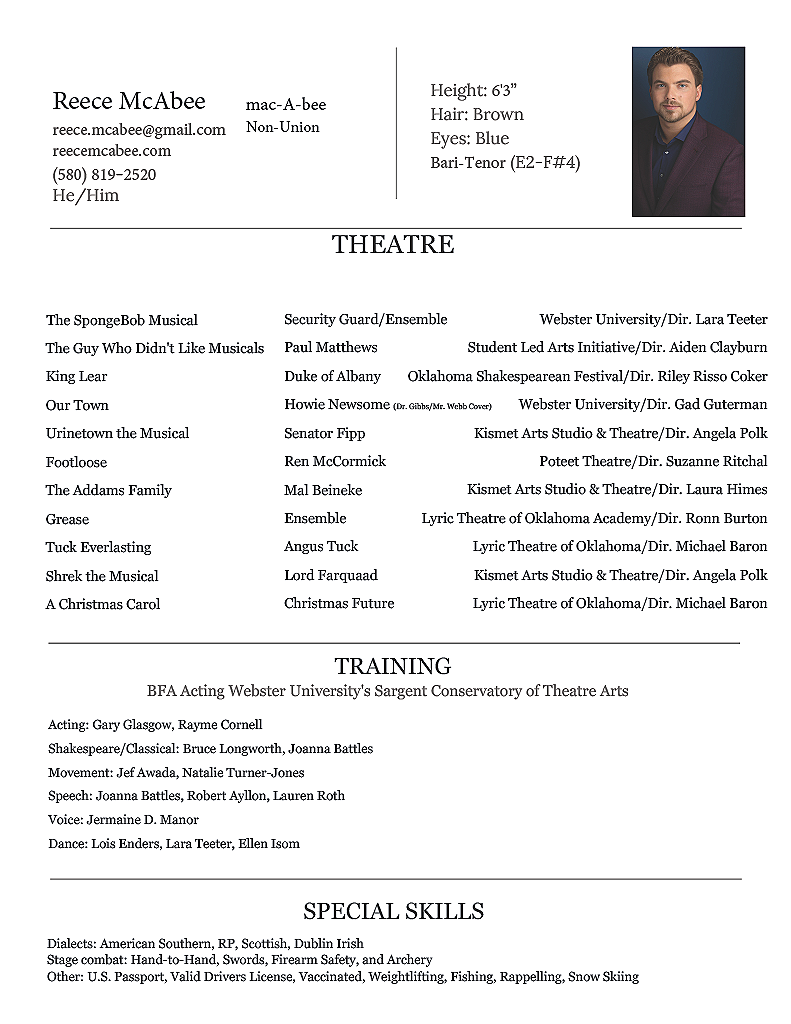 Headshot of a man with brown hair, beard, wearing a dark blazer and shirt, against a dark background.