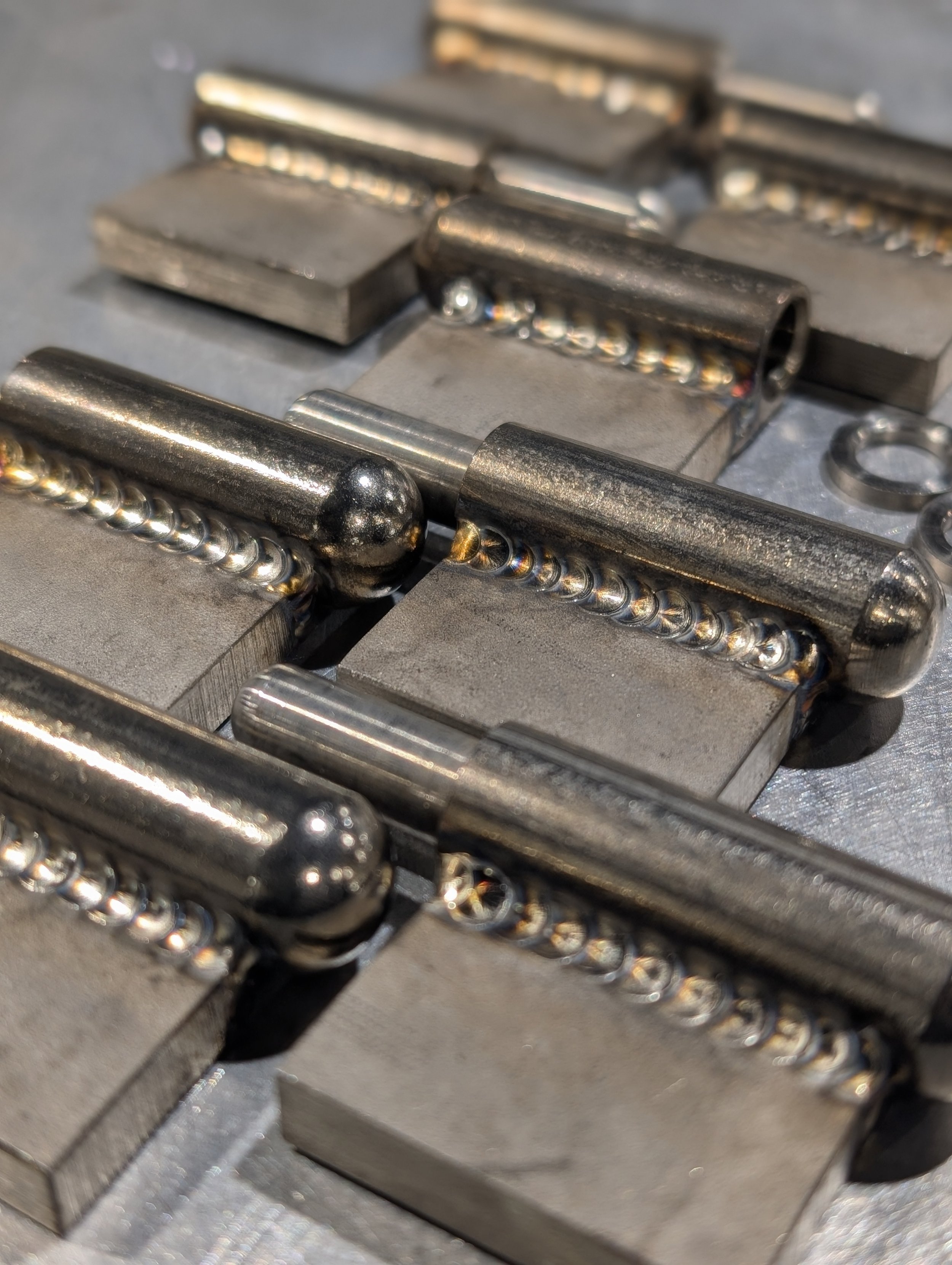 Close-up of multiple welded stainless steel hinges.