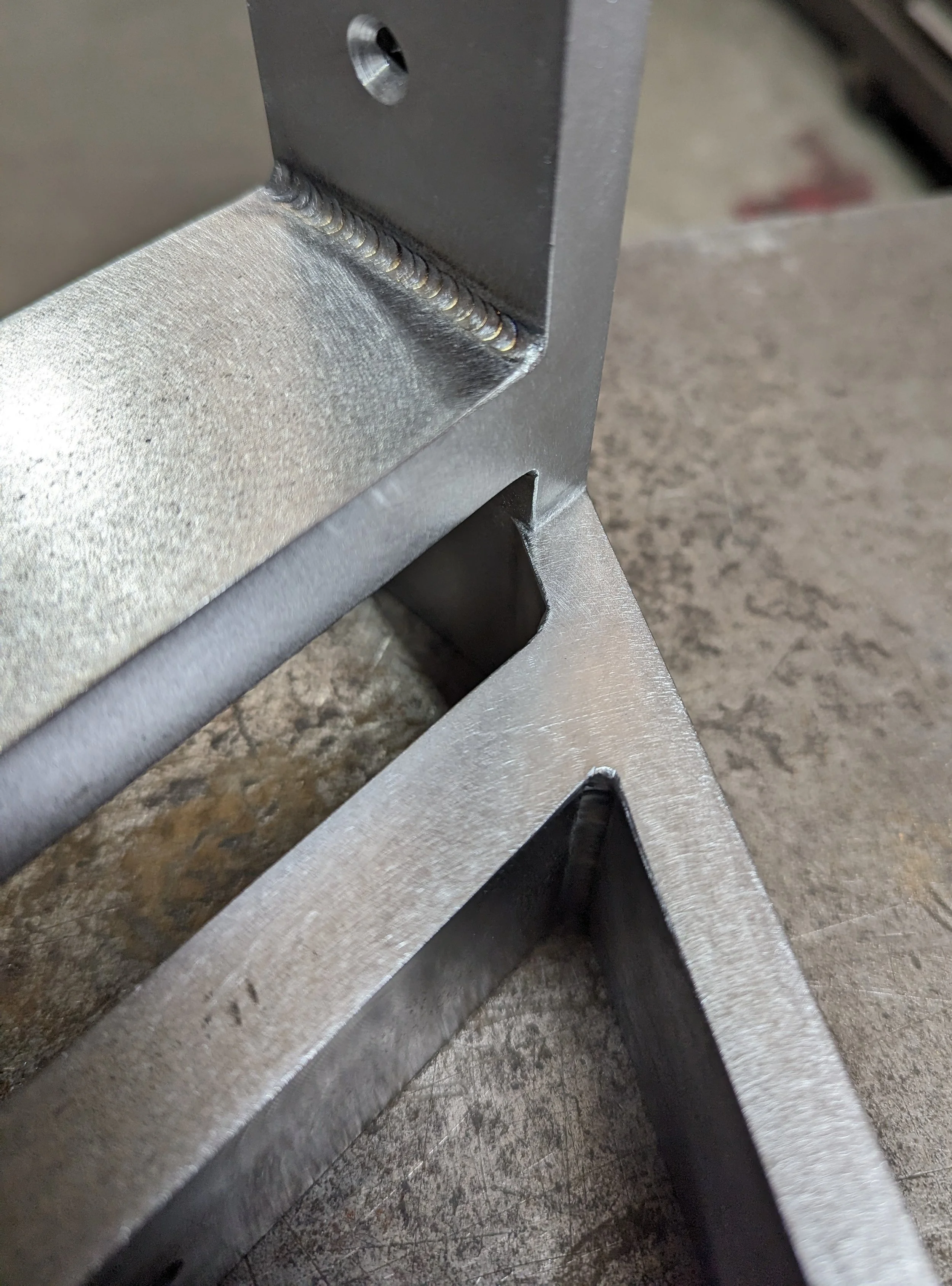 Close-up of welded metal railing corner on a workbench.