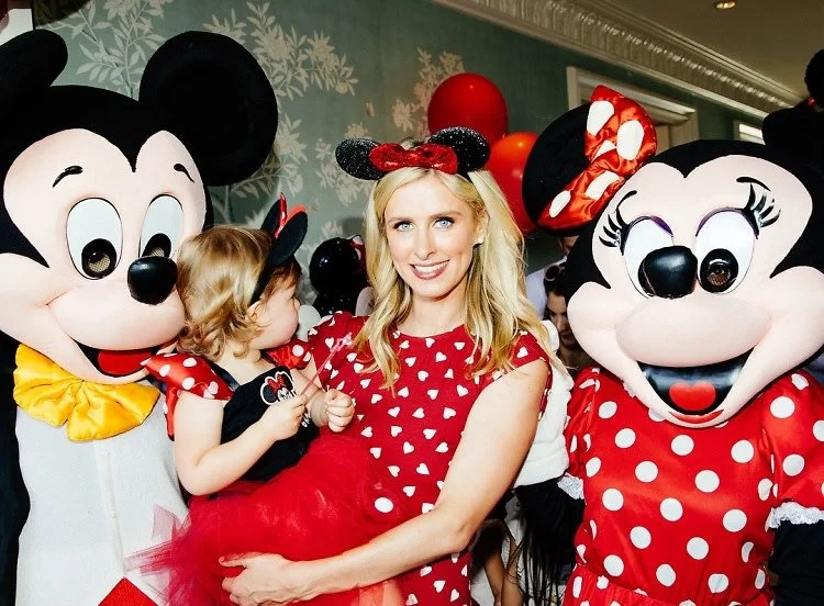 Woman and young girl with Minnie Mouse characters at a party or event.