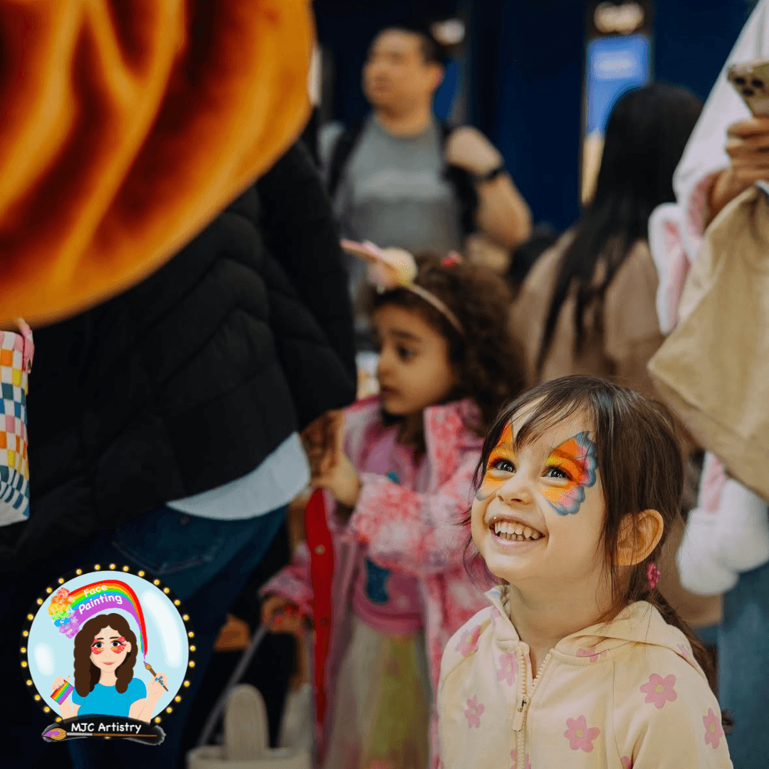 Young girl with butterfly face paint staring up at the easter bunny at Capilano Mall in North Vancouver