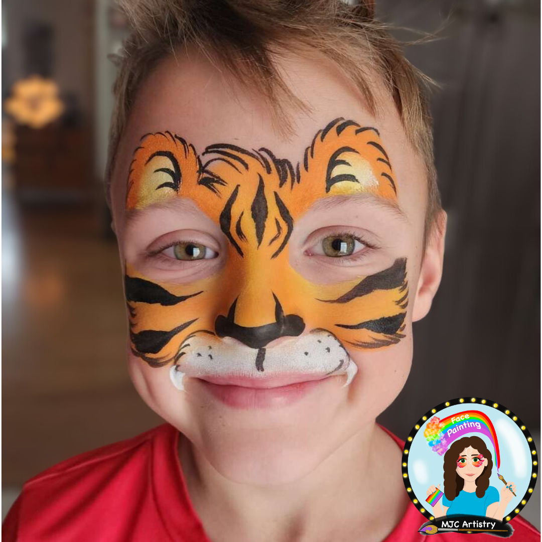 Child with face painted as a tiger, featuring orange, black, and white colors, and wearing a red shirt at a birthday party in Vancouver. 