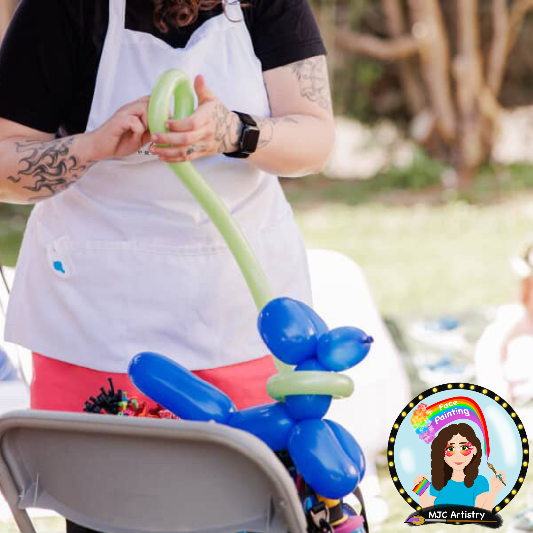 Person creating a balloon animal at outdoor event, with a logo for face painting and balloon art in the corner.
