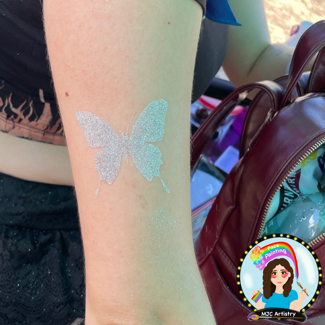 Silver glitter butterfly temporary tattoo on a person's arm.