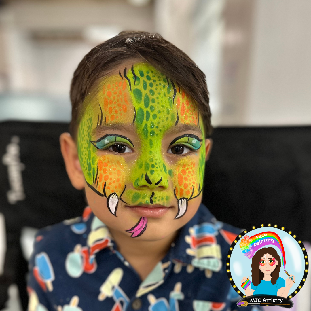 Child with face painted as a colorful snake, featuring green, orange, and black details, with a tongue sticking out. Face painting at a birthday party in Vancouver.