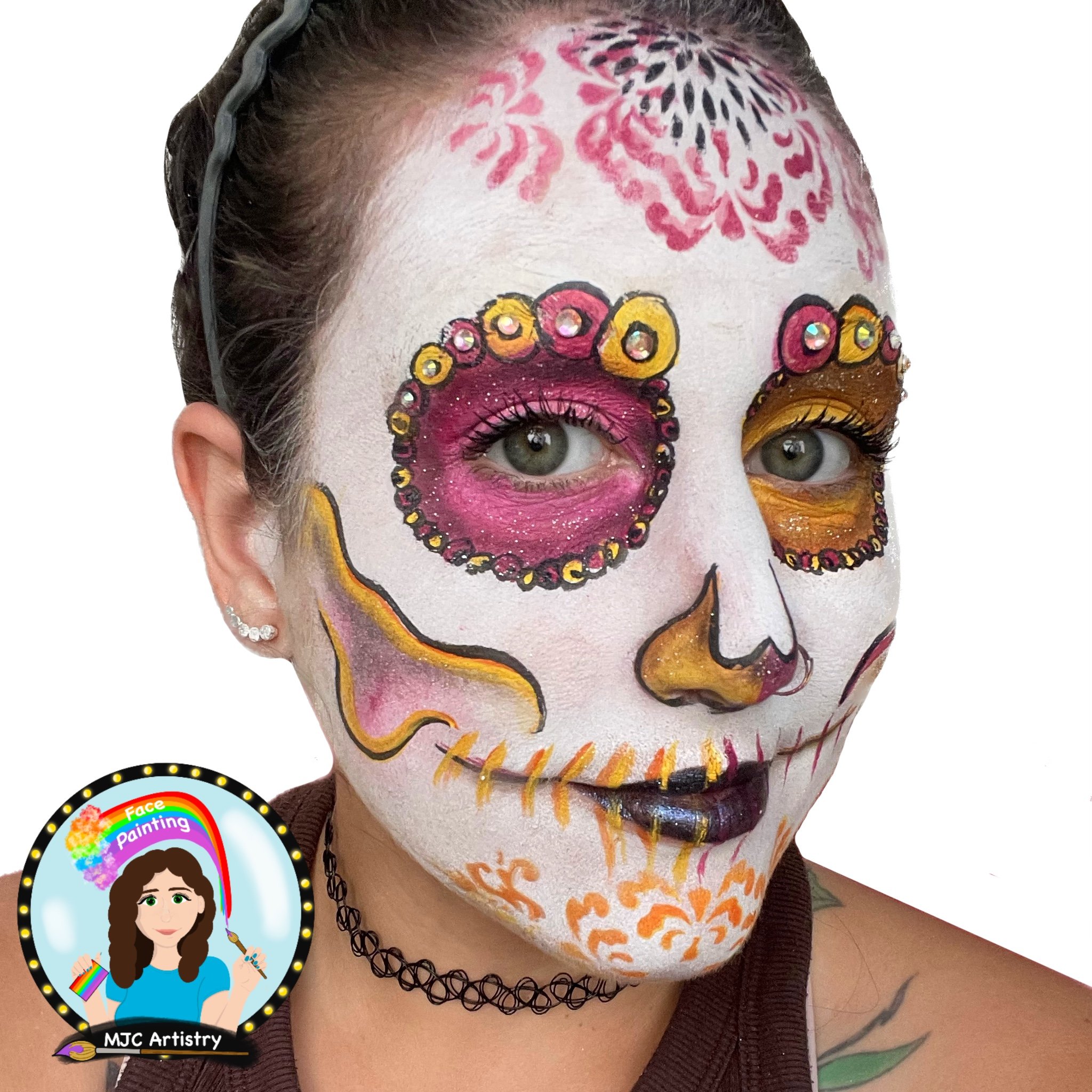 Woman with face painted as a sugar skull, featuring pink, orange, yellow, black, and white colors, with decorative patterns and rhinestones around the eyes, and a white background.