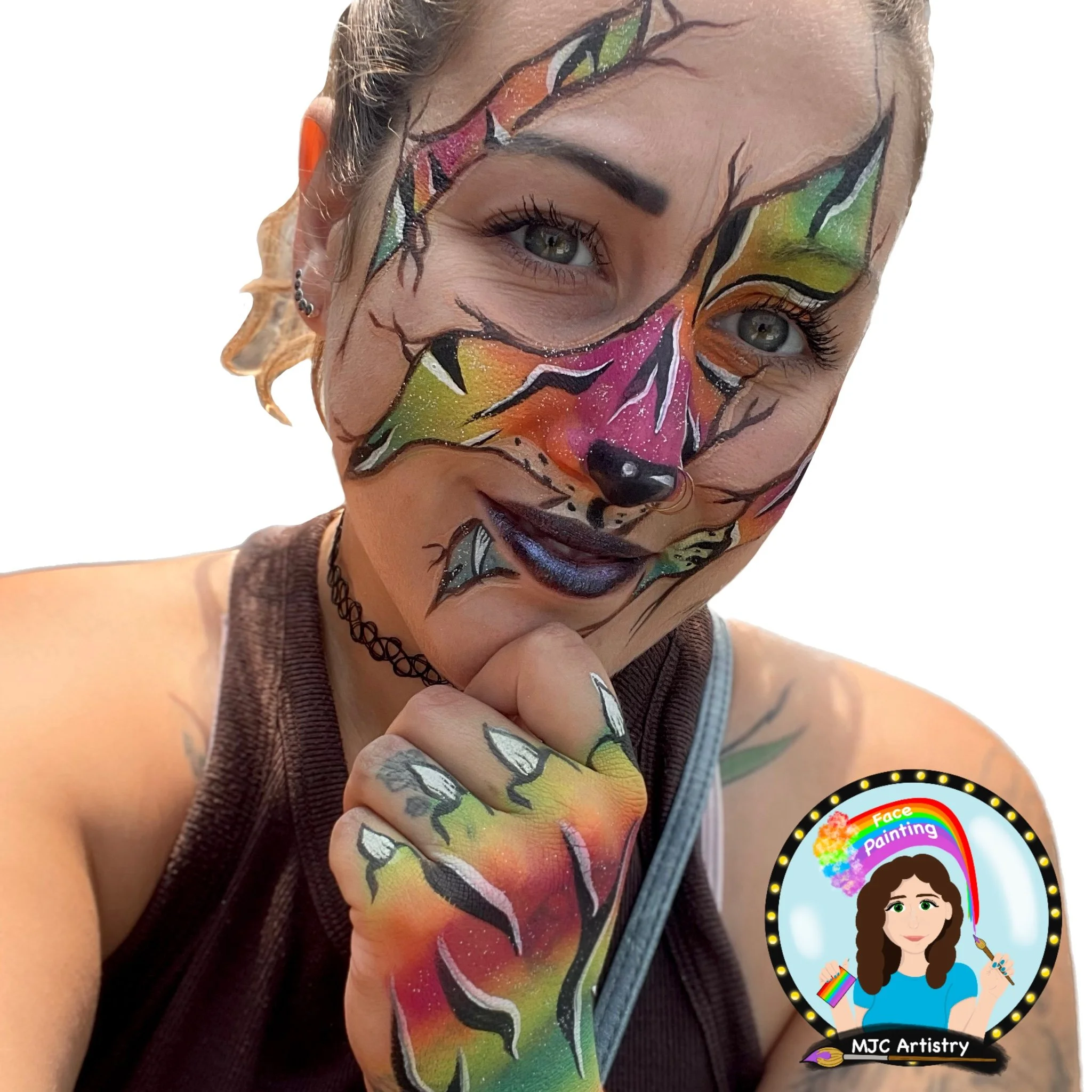 Woman with colorful fox face paint, hand on chin, wearing a black choker, tattoos, and a tank top, smiling with bright eyes.