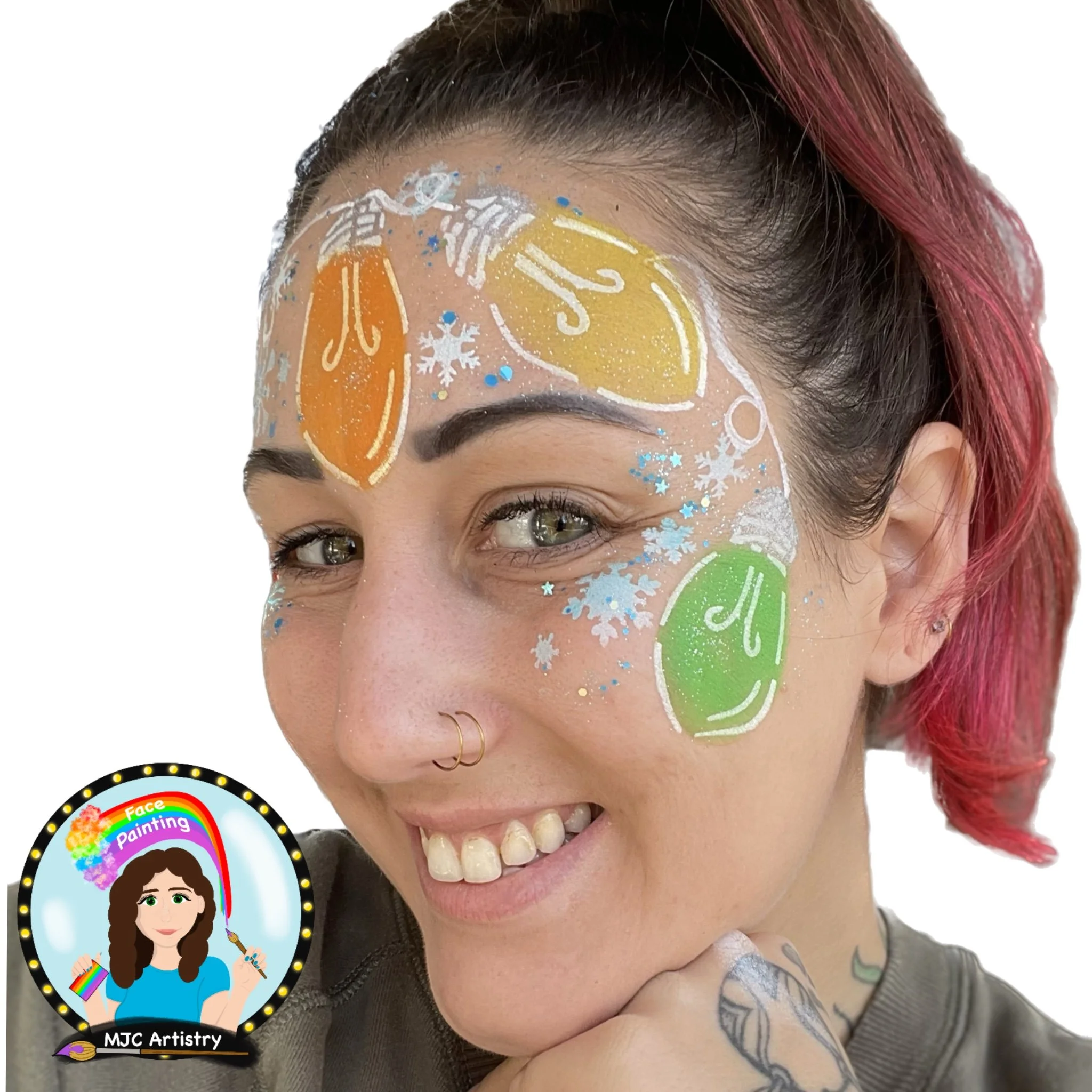 A woman with pink hair smiling, face painted with colorful ornaments and snowflakes, and a small badge of a woman face painting logo in the bottom left corner.