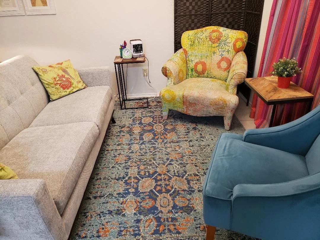 A living room with welcolming energy. There is a carpet with a floral pattern. South Austin, Texas location for counseling support. Ease. Nervous system support, Energy healing sessions. Nervous system regeneration. Past-life regression.