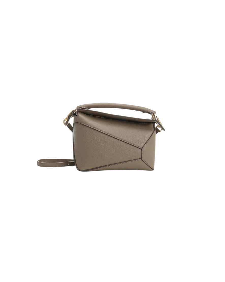 A light gray structured leather handbag with a geometric stitch design and a strap handle, displayed against a plain background.