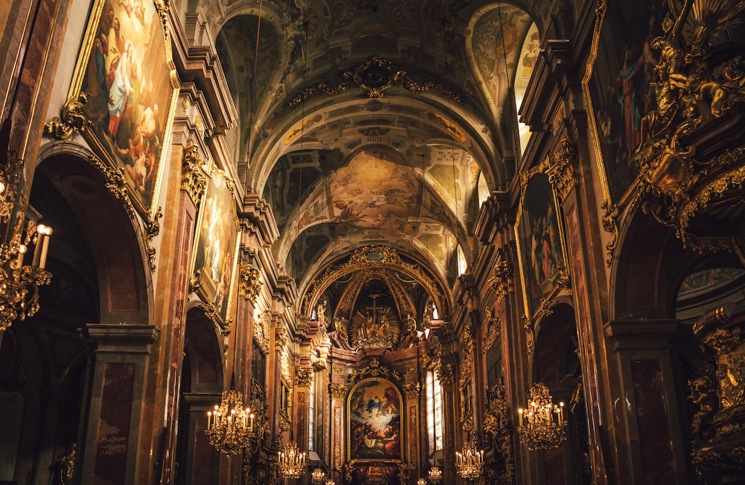 Luxury church interior with gold accents, chandeliers, and religious artwork on the walls and ceiling.