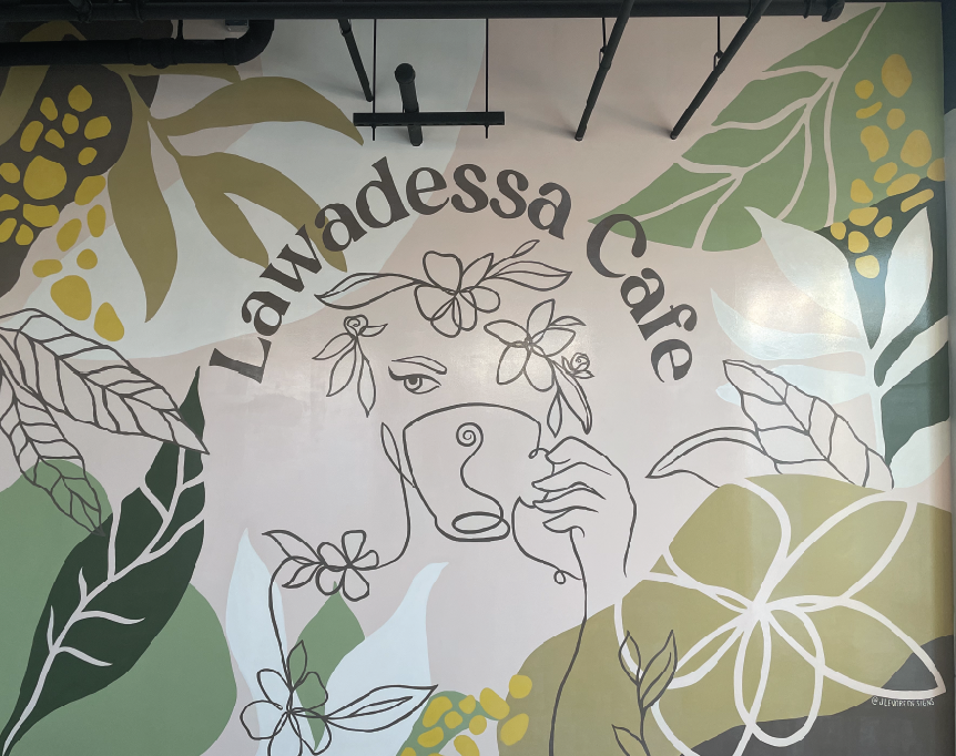 Wall mural for Lawadessa Cafe featuring abstract line art of a woman holding a coffee cup surrounded by large stylized leaves, floral designs, and the cafe name in a semi-circle.