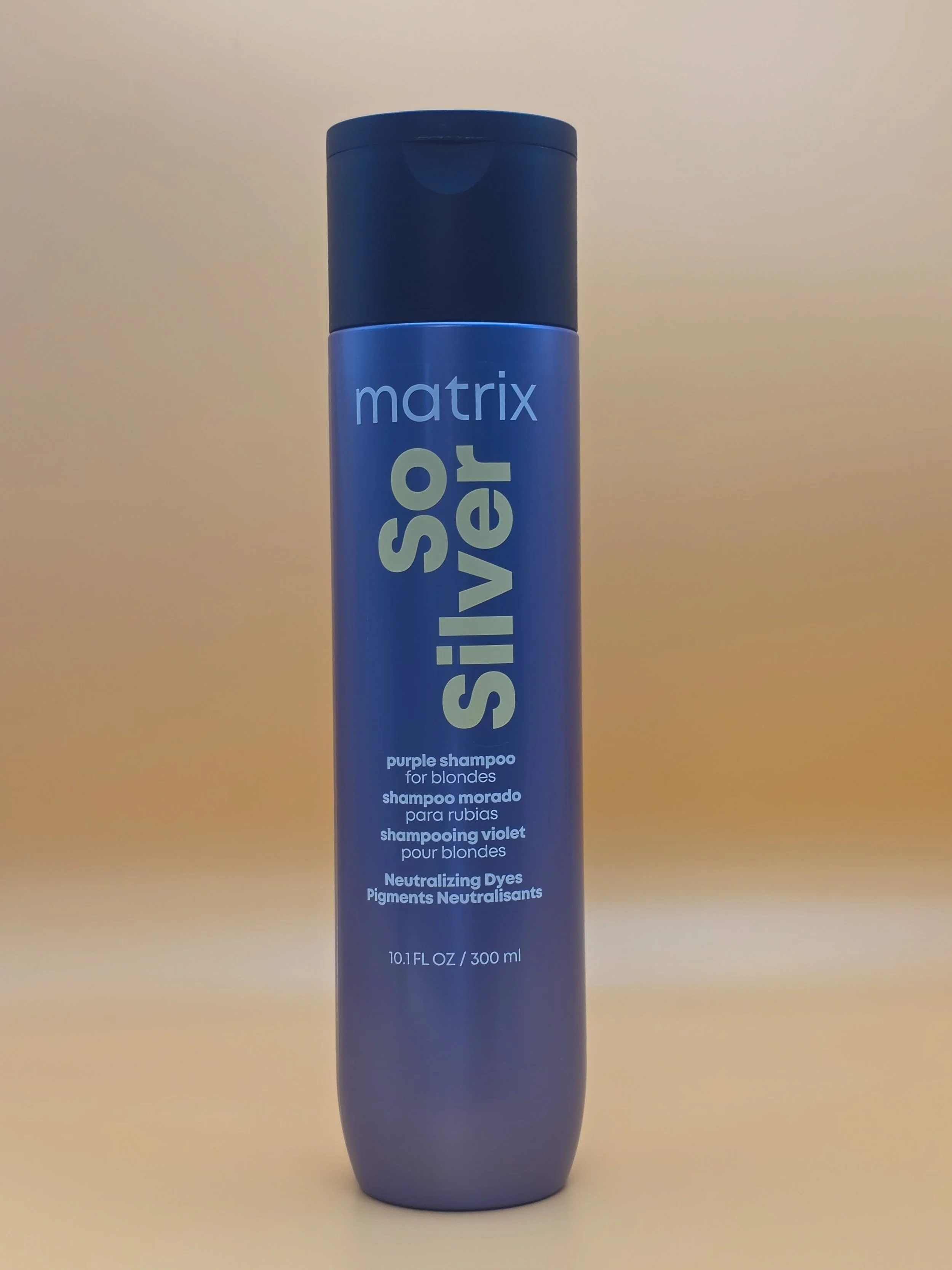 A cylindrical bottle of Matrix So Silver purple shampoo for blondes with a blue cap, labeled with product information and volume of 10.1 fluid ounces (300 ml).