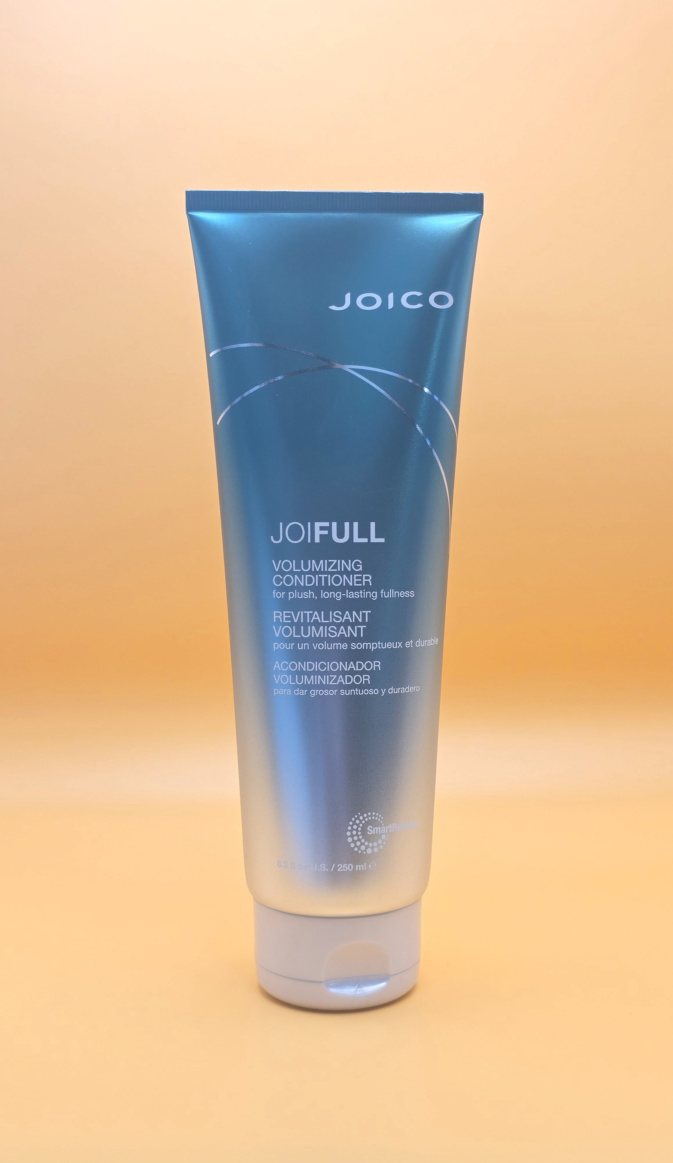 A tube of Joico Joifull volumizing conditioner standing upright against a yellow background.