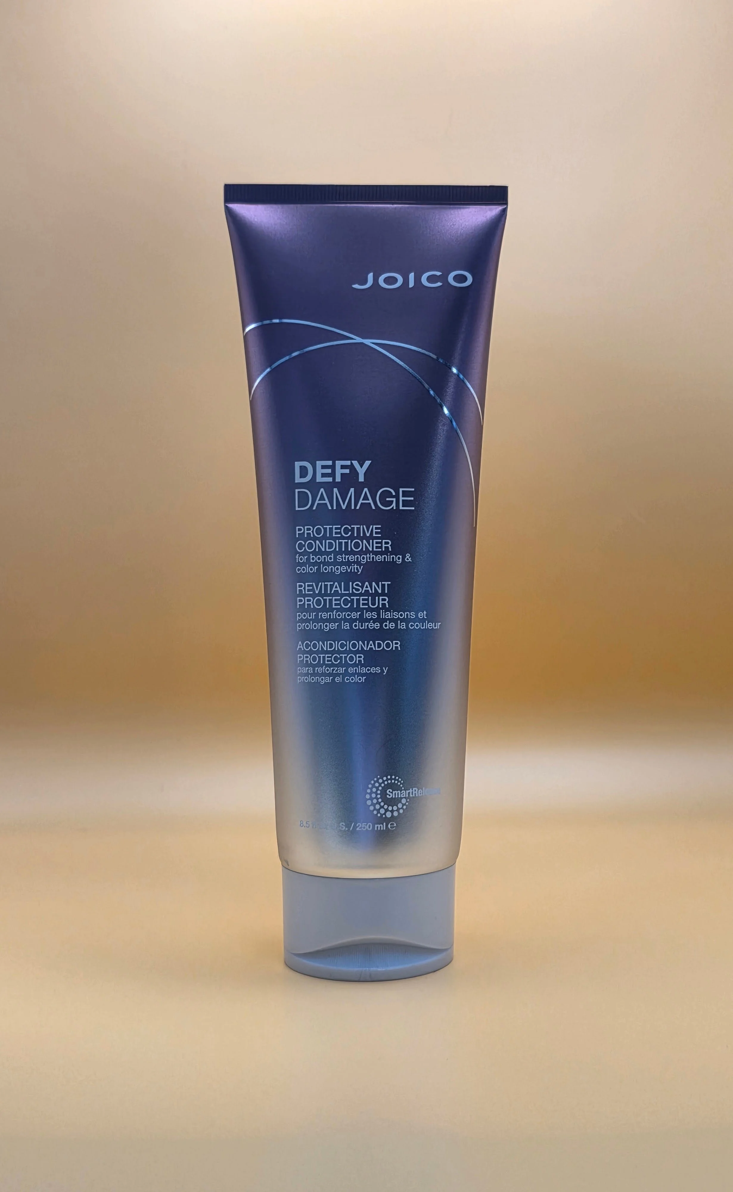 A tube of Joico Defy Damage Protective Conditioner against a neutral background.