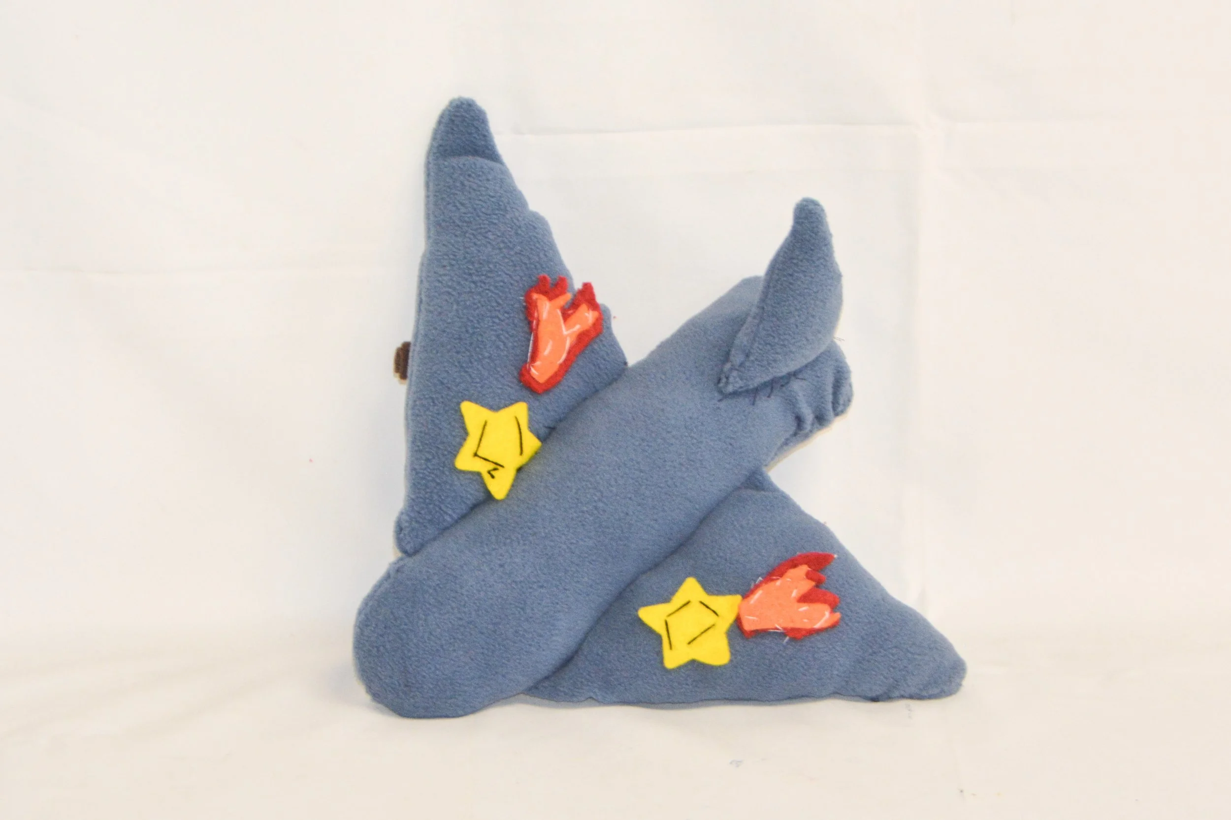 Gray plush hand puppet with star and flame patches, resembling a character with pointy ears, on a white background.