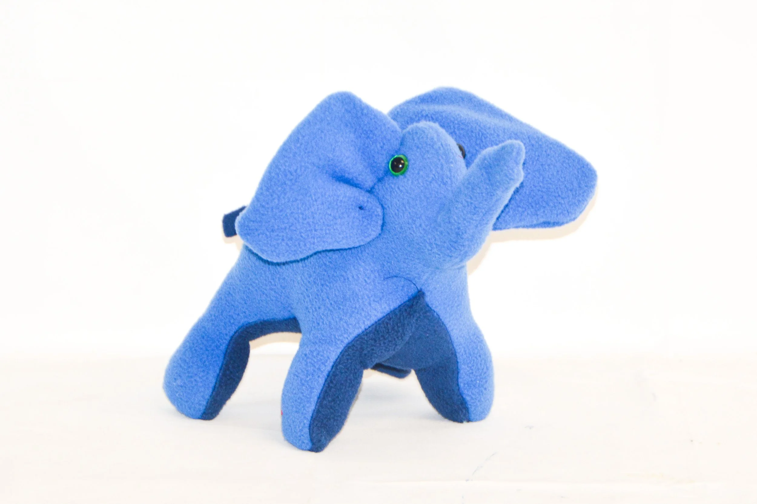 A plush toy elephant in blue with darker blue accents on its legs, ears, and trunk, set against a plain white background.