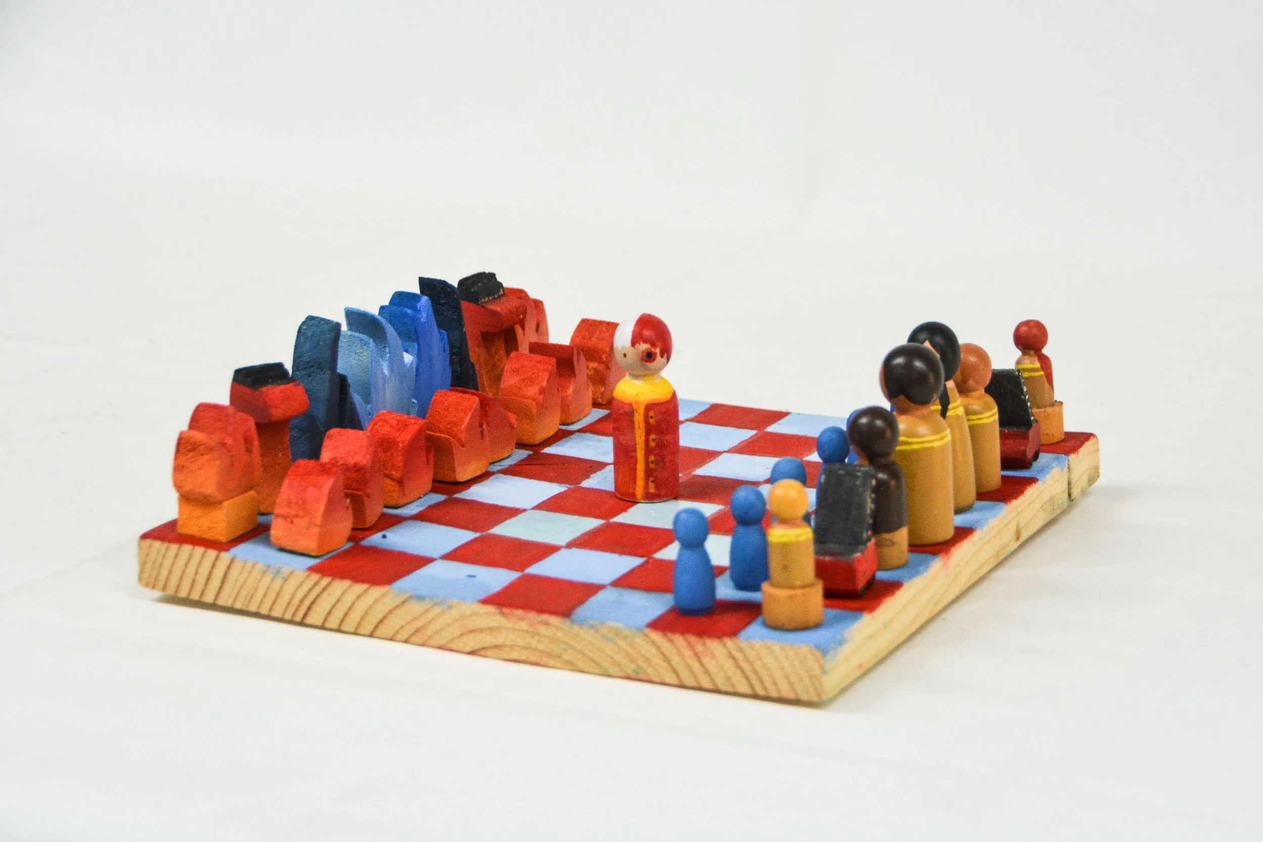 Wooden chess set with painted pieces on a checkered board.