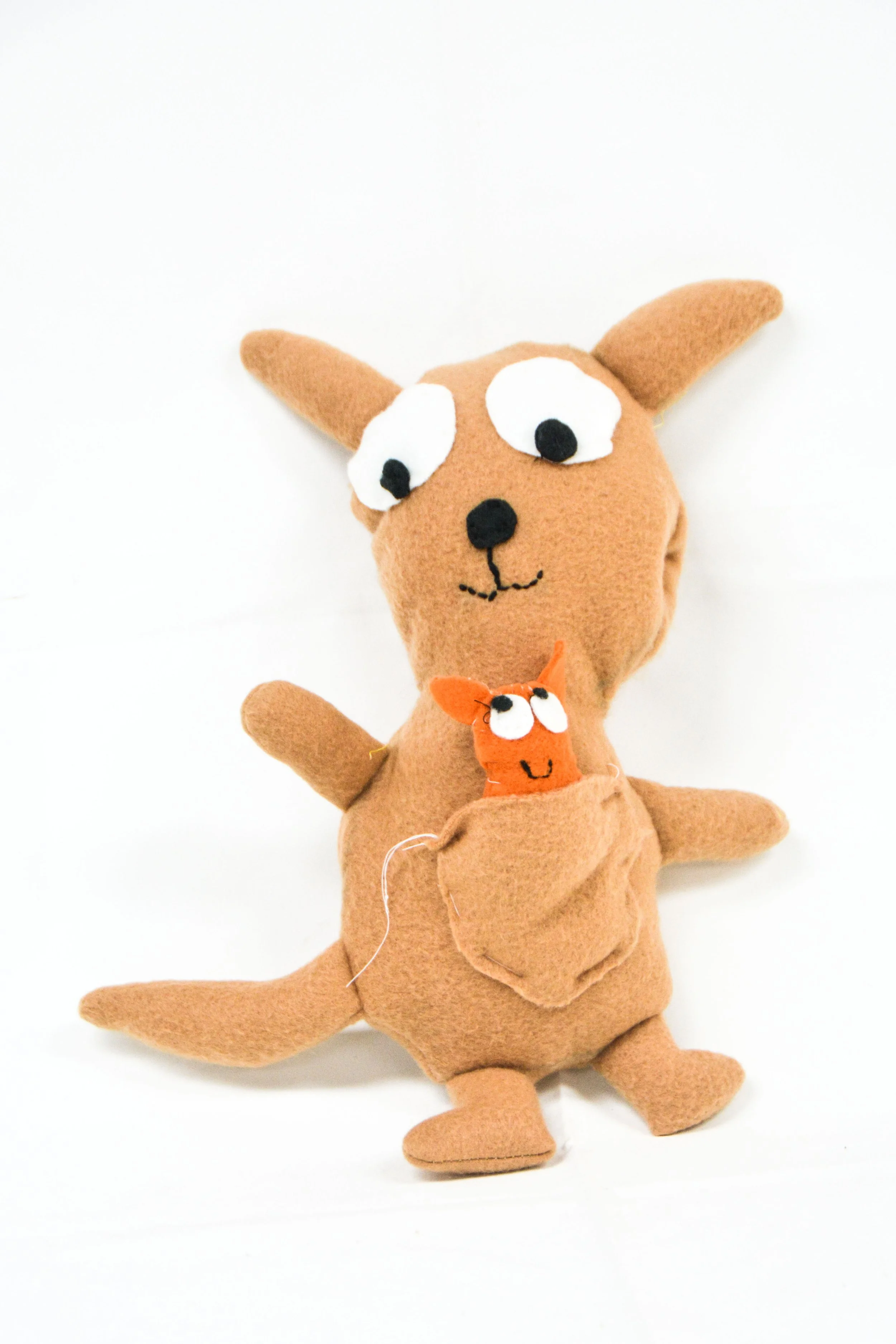 Two plush toys resembling animals with exaggerated eyes, one larger and one smaller, against a white background.