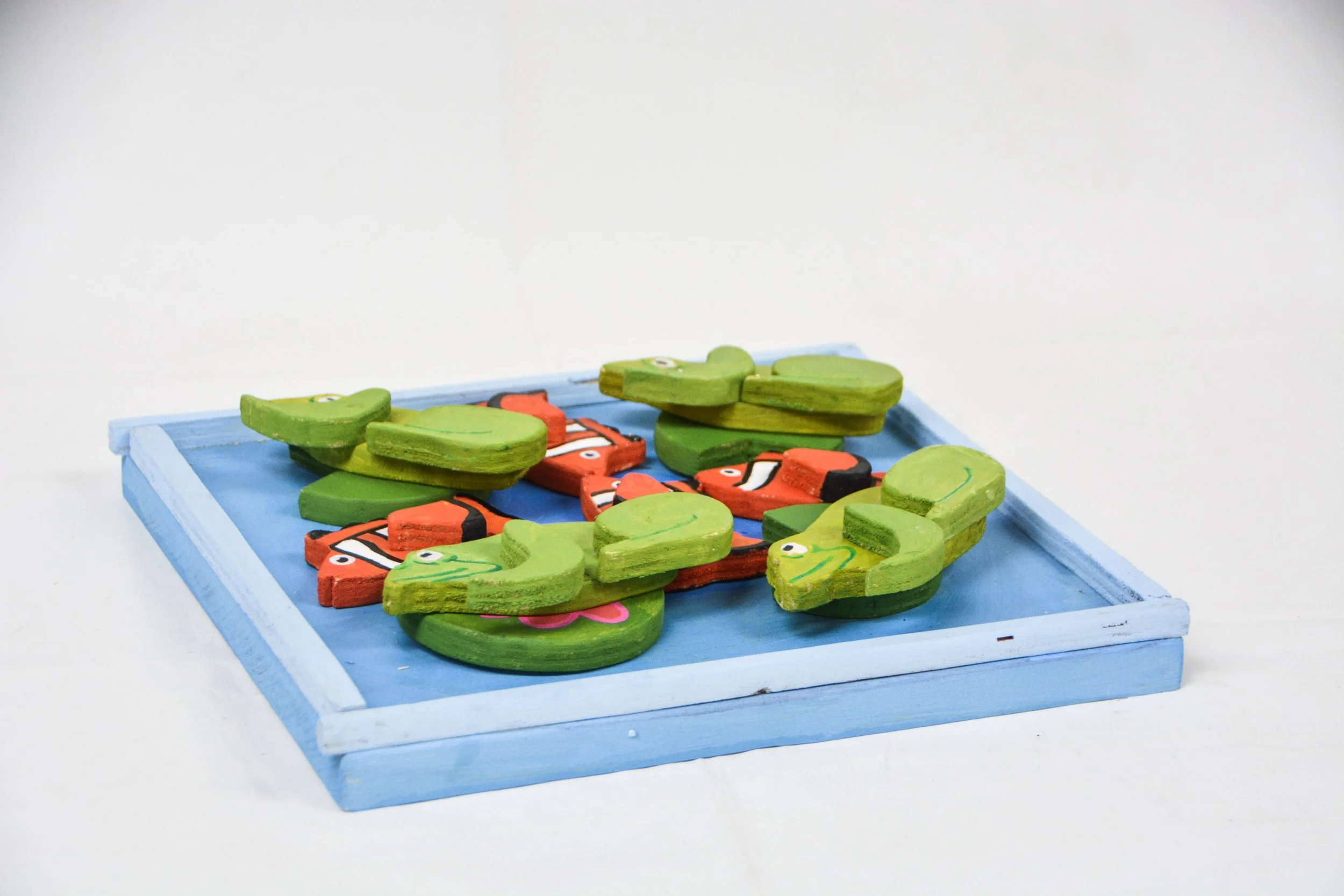 Colorful wooden dinosaur puzzle pieces on a blue tray.