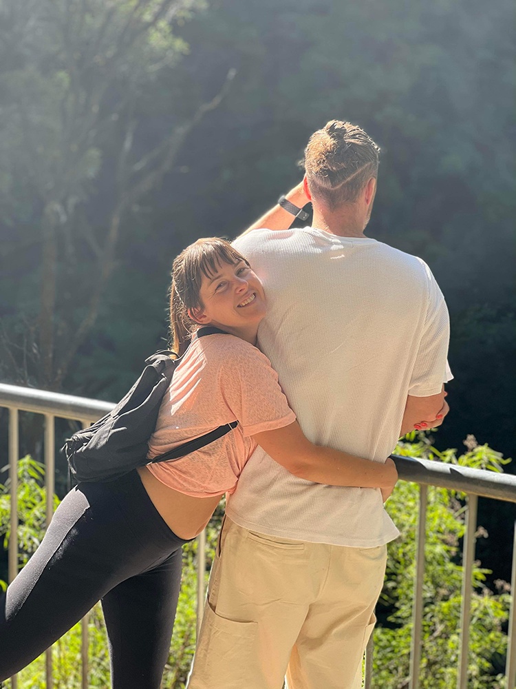 Photo of a woman hugging a man around his waist with a big ol' cheesy grin on her face